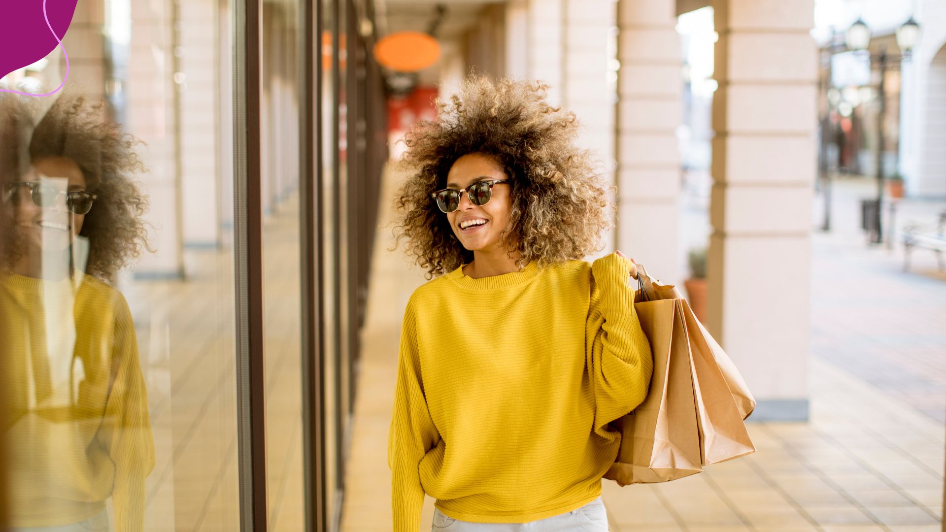 Woman in Yellow sweater with natural hair shopping and smiling 