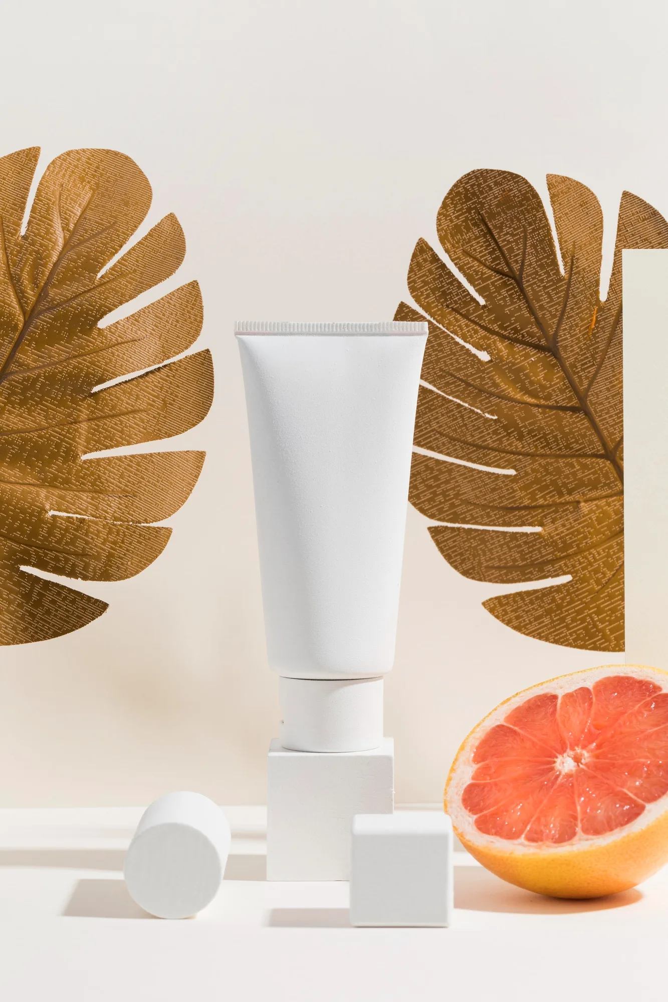 cosmetic tube framed by gold leaves