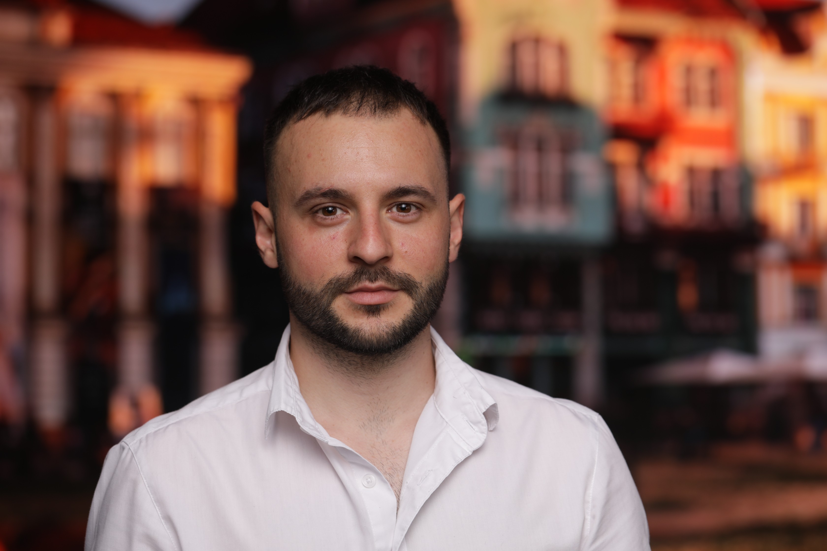Woman working on a laptop computer at a table in a bright room.