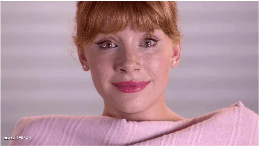 Close-up of a smiling character from the Black Mirror episode 'Nosedive,' highlighting the character's polished appearance, reflecting the social media-driven society depicted in the episode.