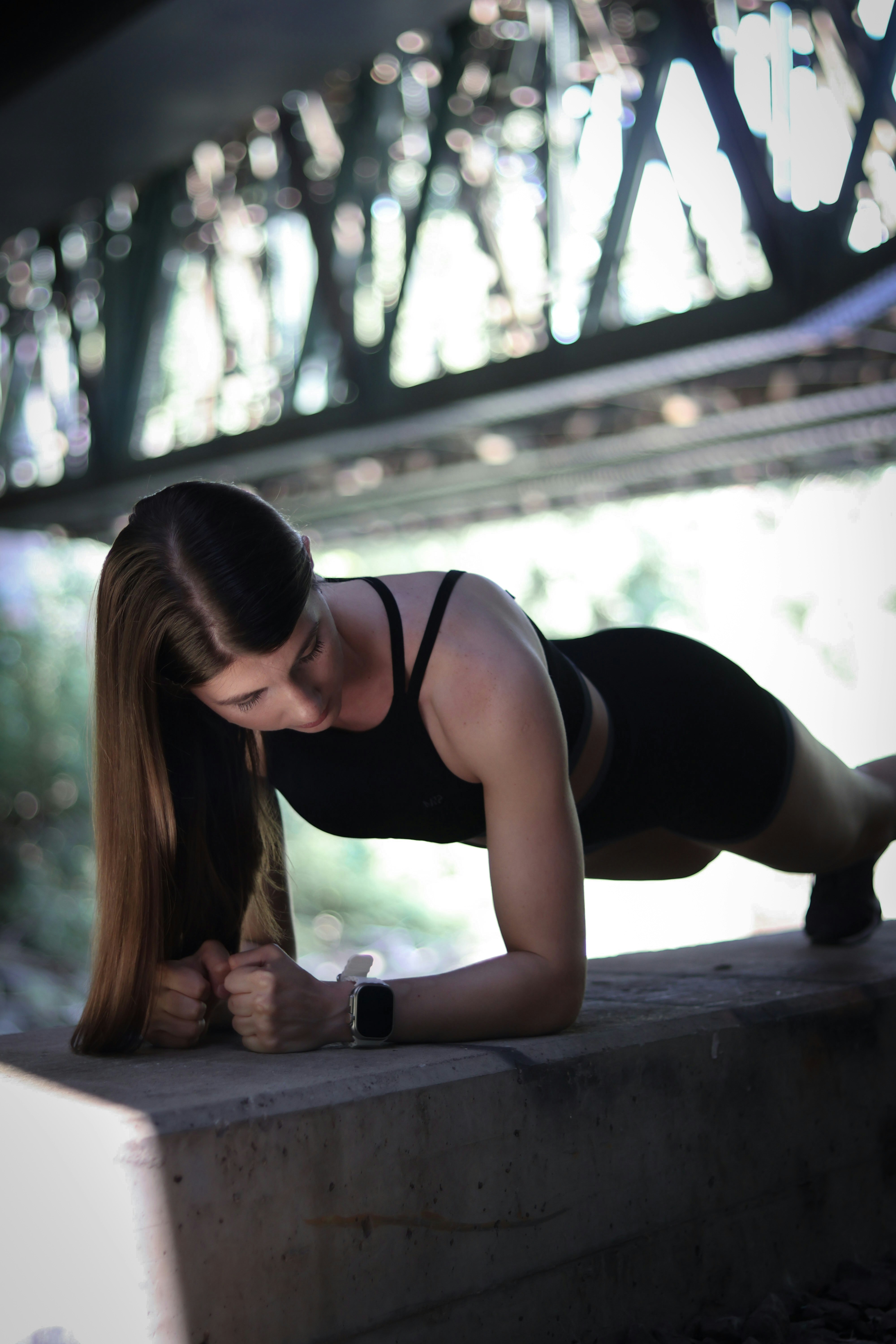 A woman in a black top is doing a push up