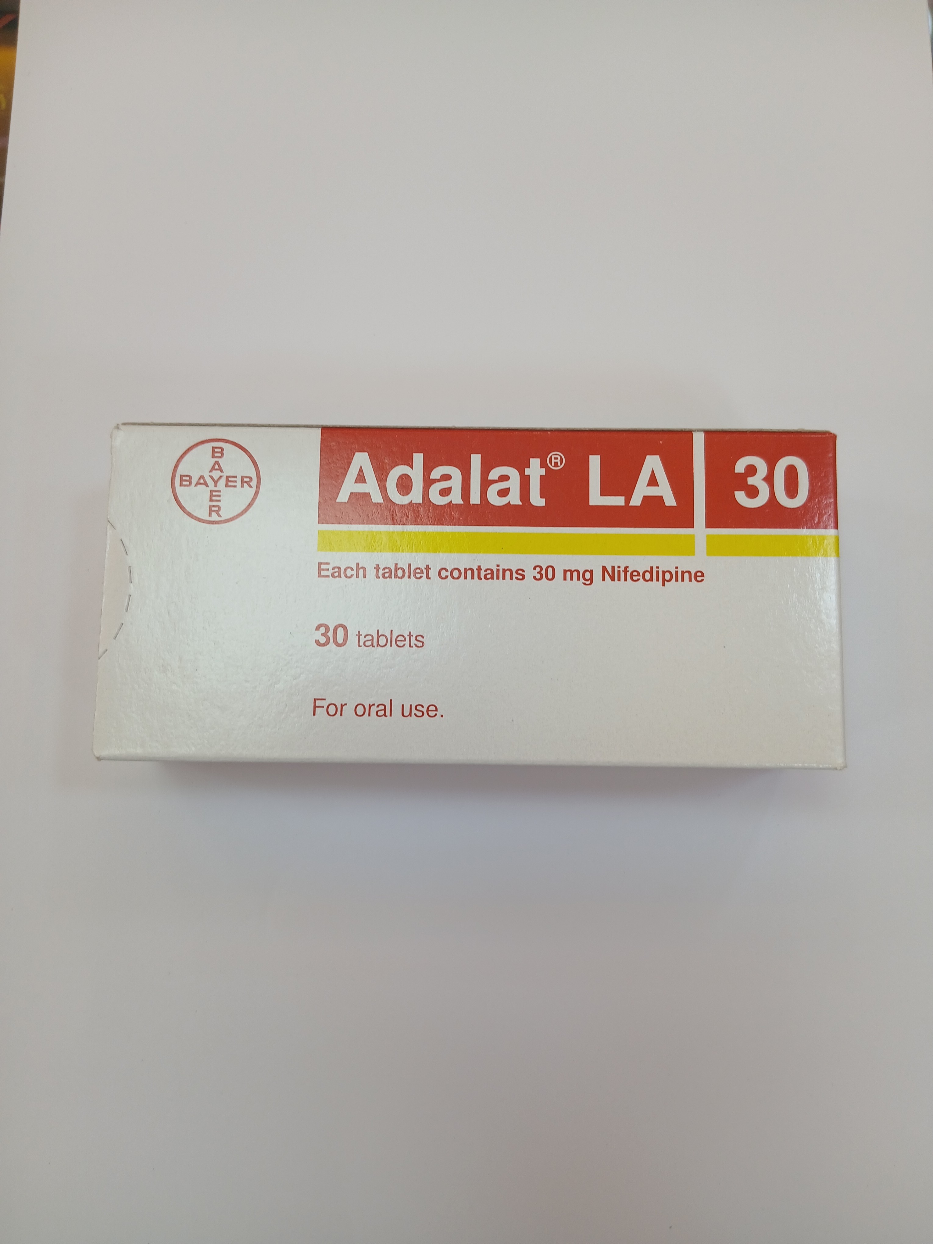 White cardboard box packaging containing 30 orange and white tablets arranged inside, labeled with black and yellow text indicating each tablet contains 30 mg of an active ingredient.