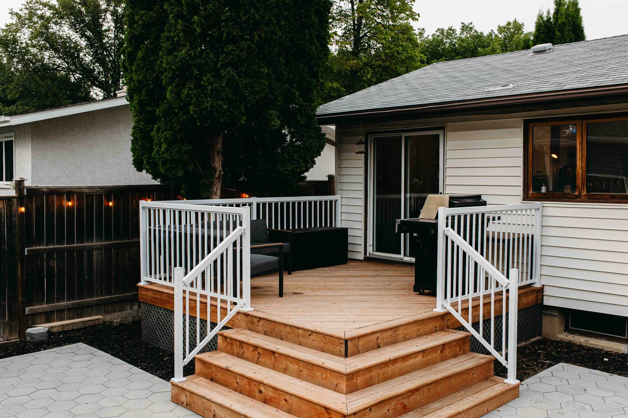 A Saskatoon deck after renovation by Oak and Ember showing a home behind it