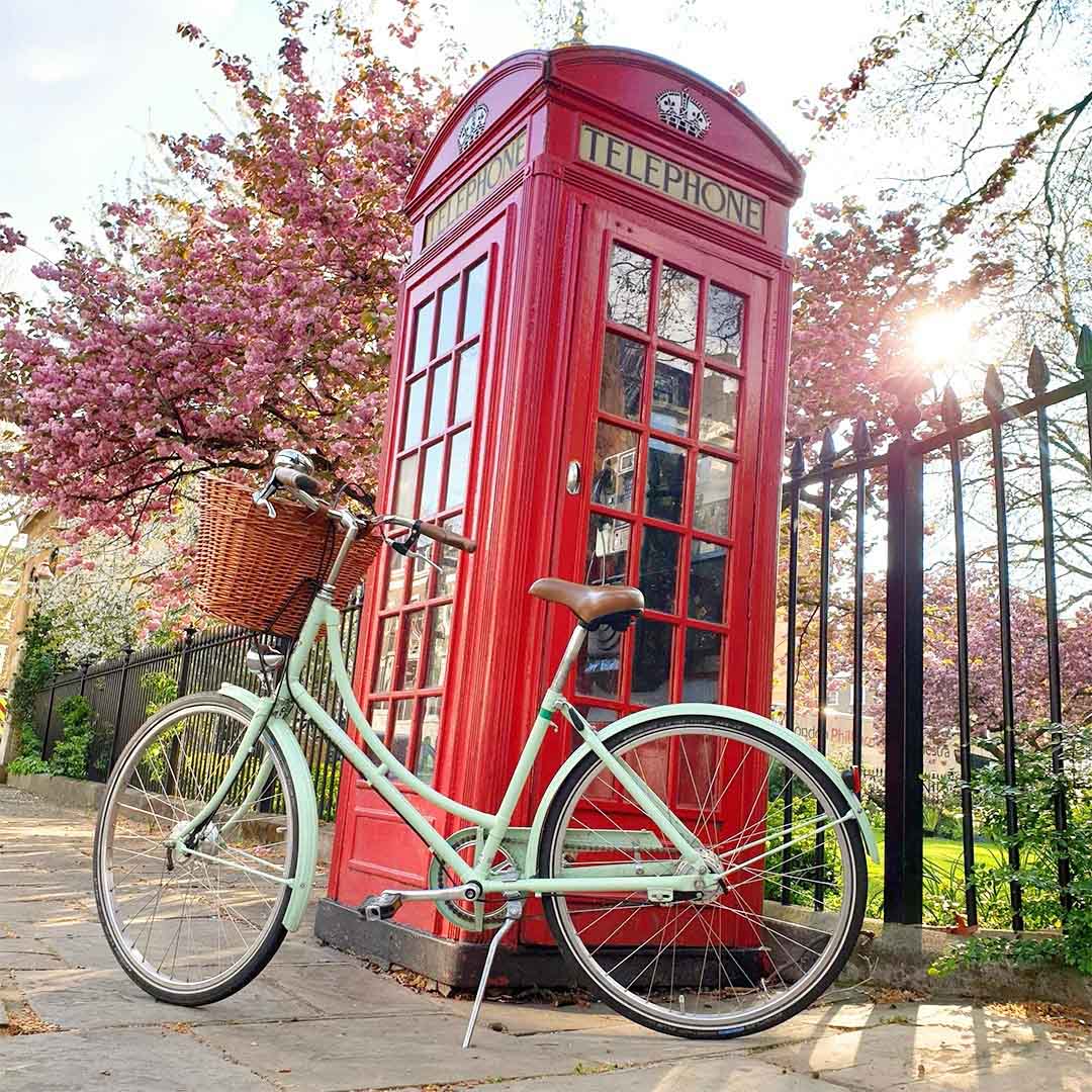 A classic Pashley bicycle next to a red phone box 