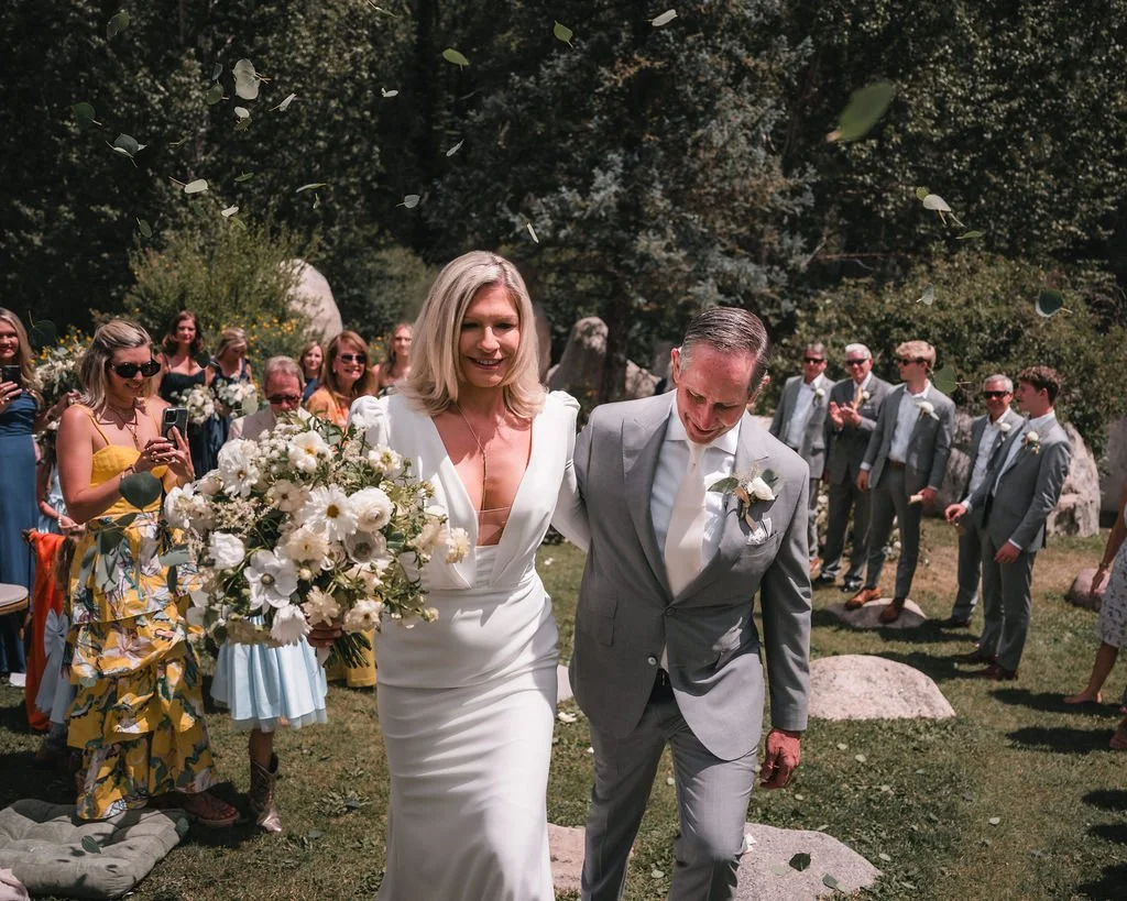 Newlyweds leaving their ceremony as guests blow bubbles