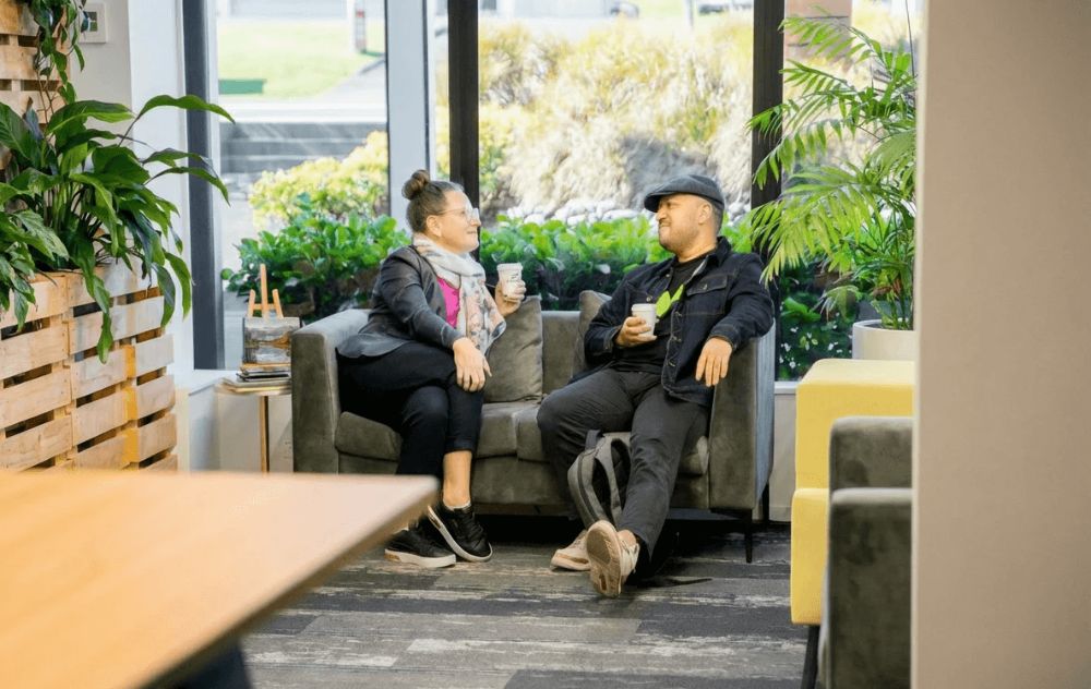 Cropped shot of man and woman chatting and drinking coffee in the Business Lounge at The Crate Albany-Rosedale.