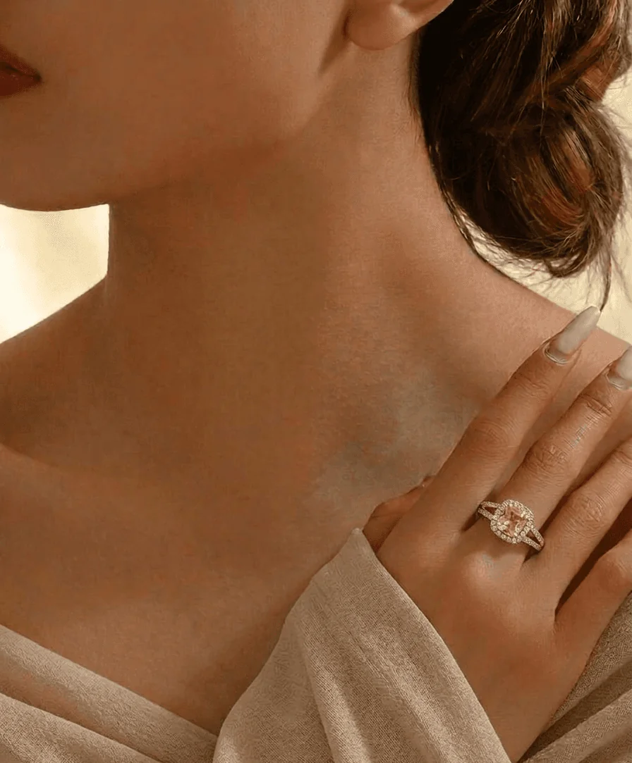 A close-up of a woman's shoulder and neck, with her hand gently resting on her shoulder. Soft lighting highlights her skin.