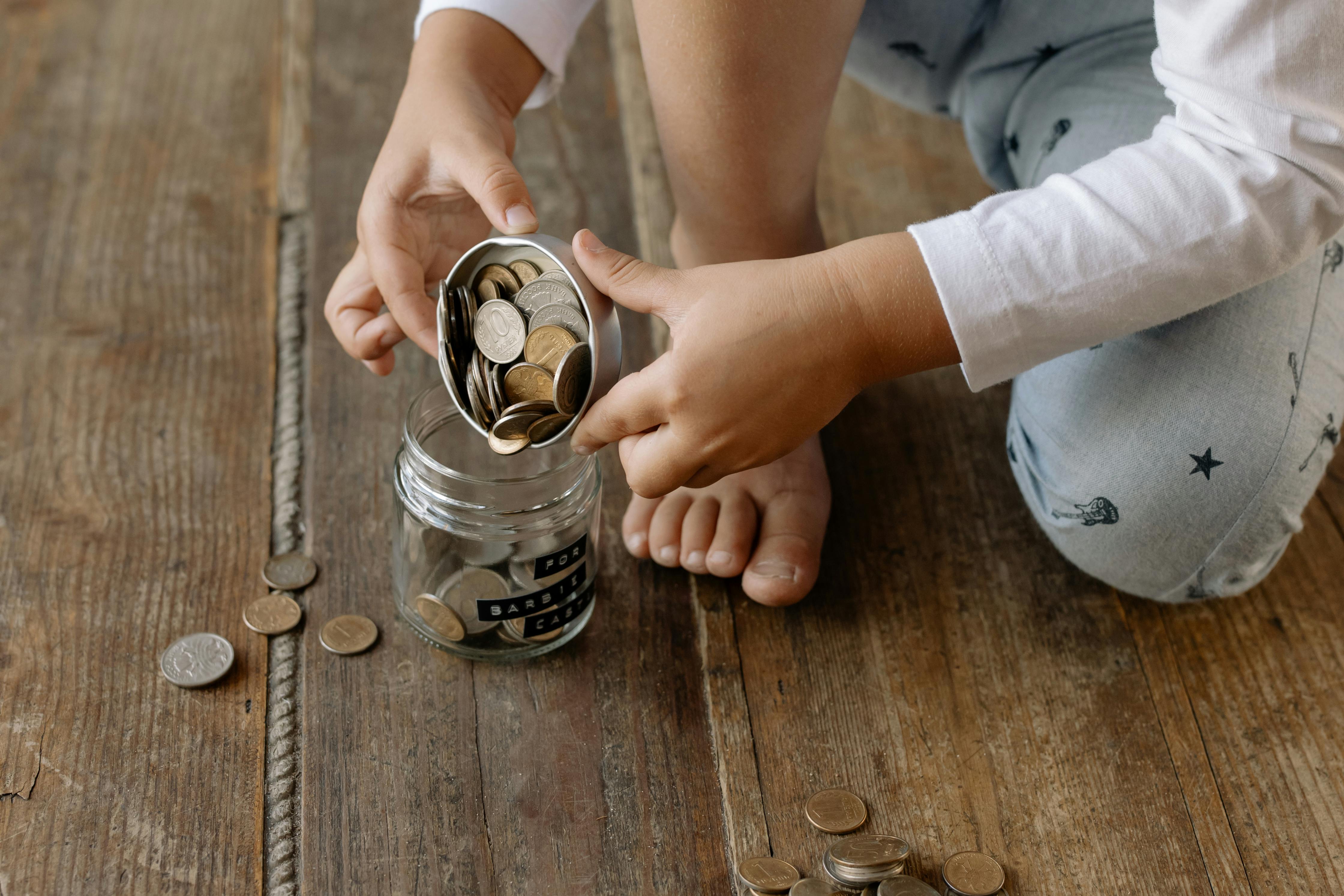 Niño guardando monedas en un frasco para representar métodos de ahorro