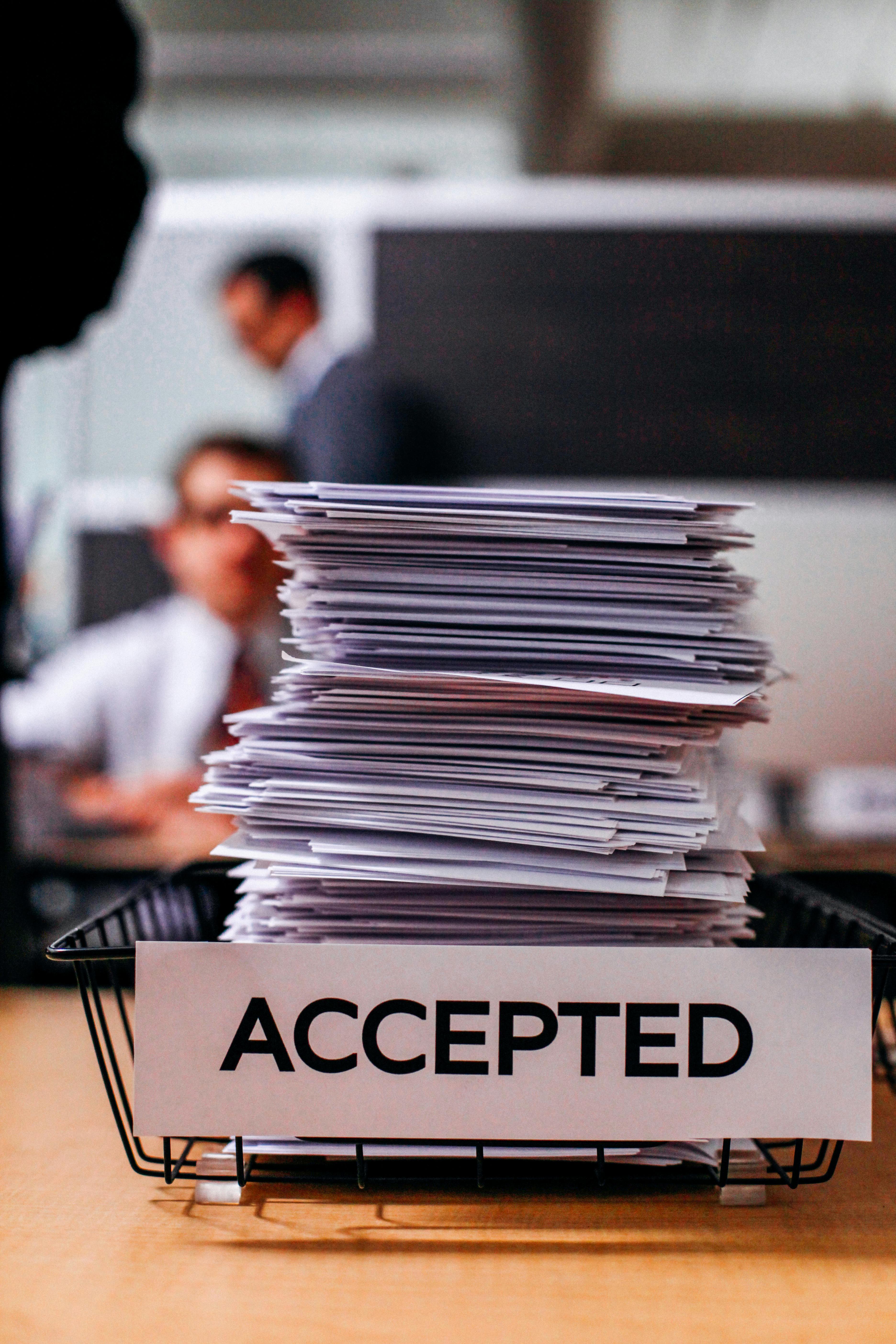 a stack of papers sitting on top of a wooden table