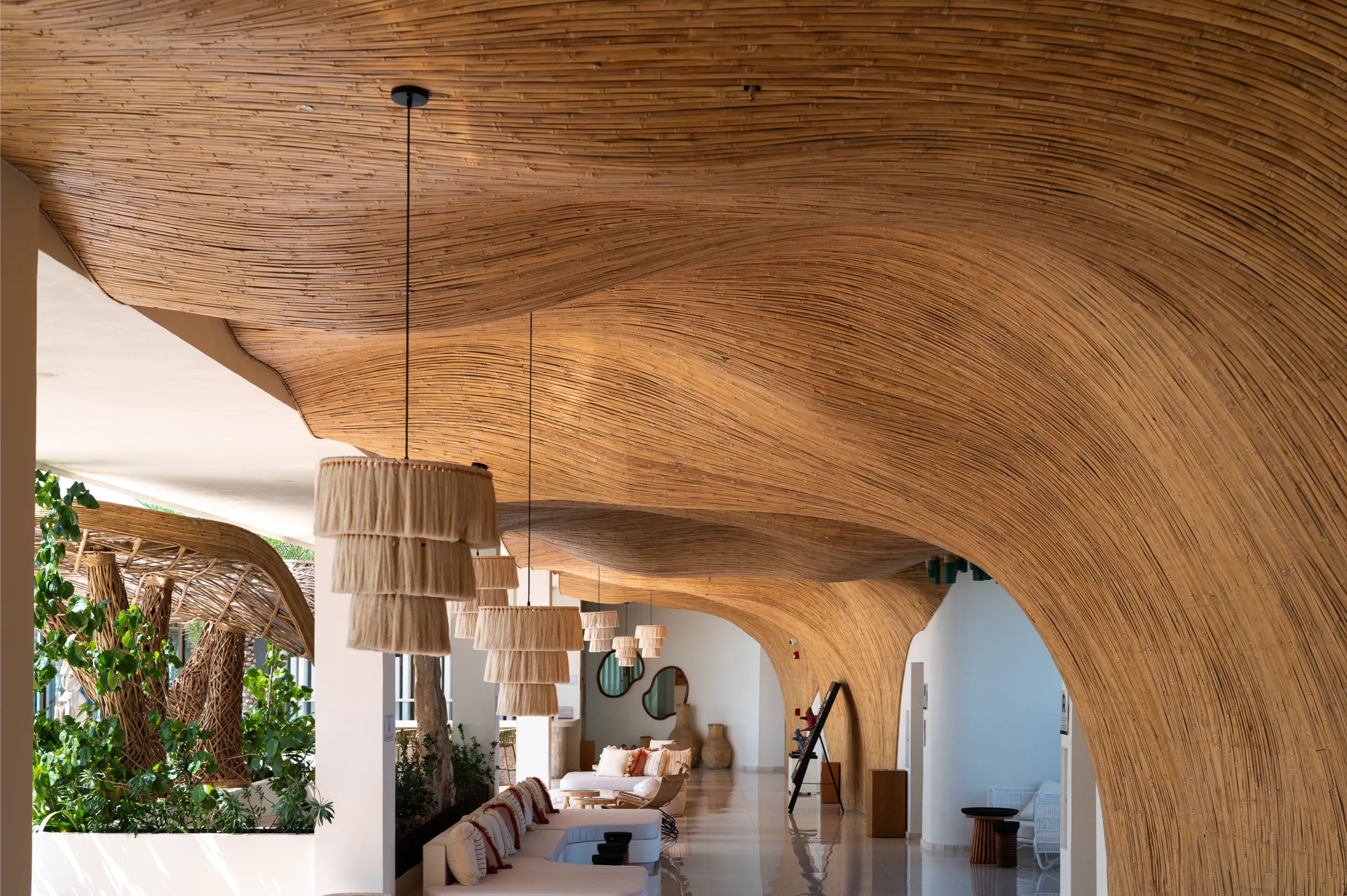 Luxurious lounge at Hyatt Impressions featuring the 'Ola' bamboo ceiling with fluid wave-like undulations.