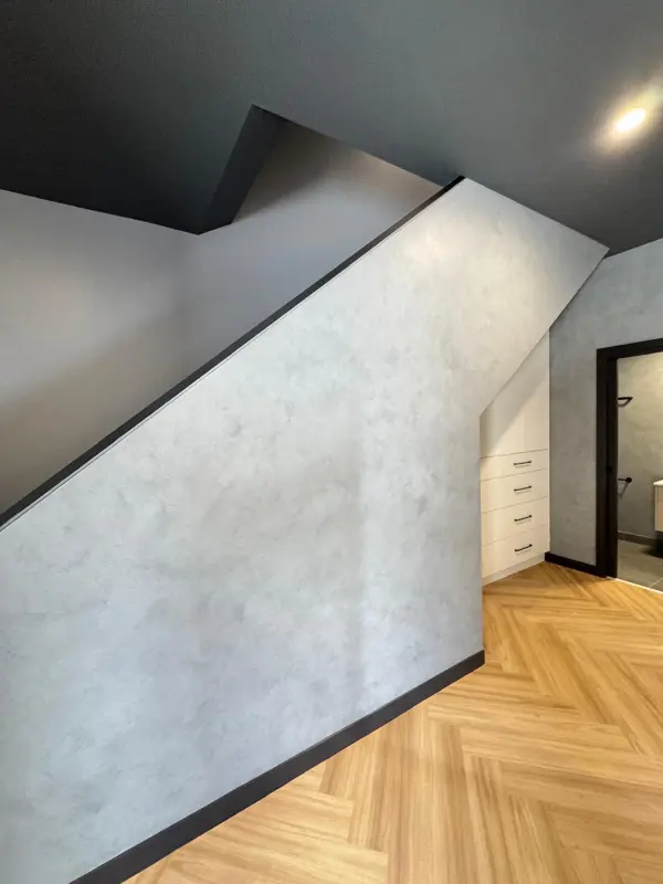 Textured feature wall finish beside warm timber flooring