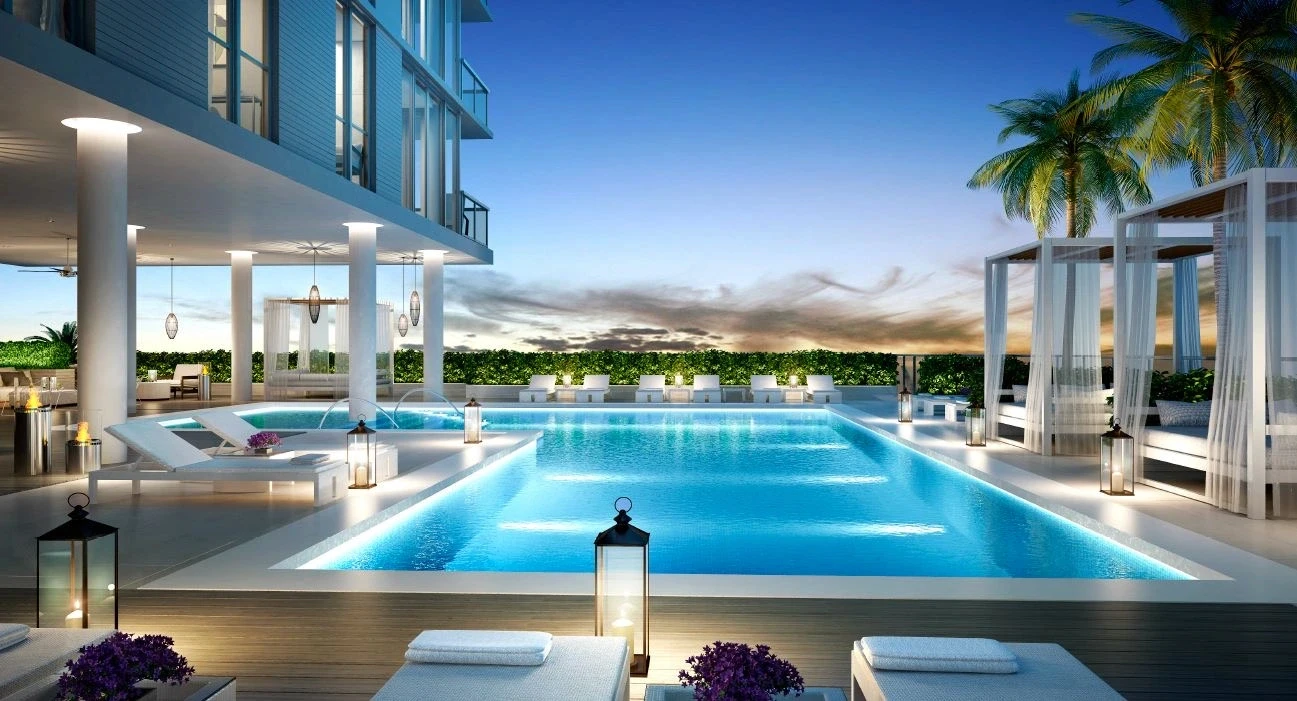 Amenity pool and tower base at Harbor Island, North Bay Village with cabanas, terraces, and floor-to-ceiling glass