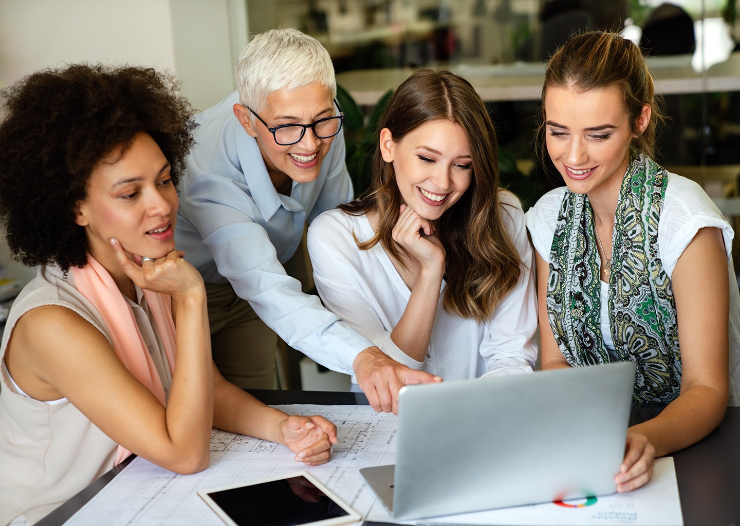 Lavoro e donne in Italia: donne attorno a un tavolo collaborano davanti a un computer.