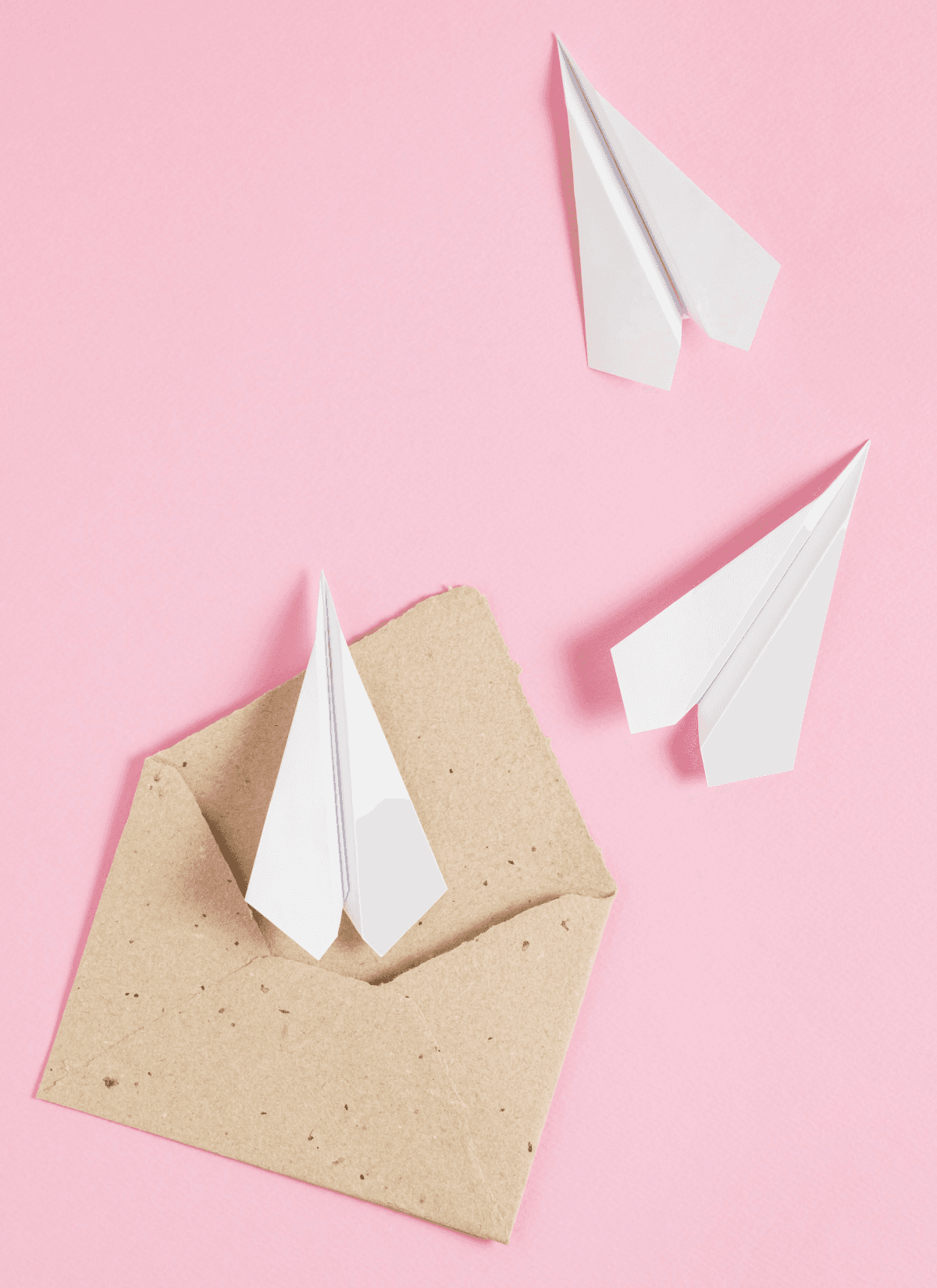 White paper planes flying out of a rustic envelope, representing seamless communication flows.