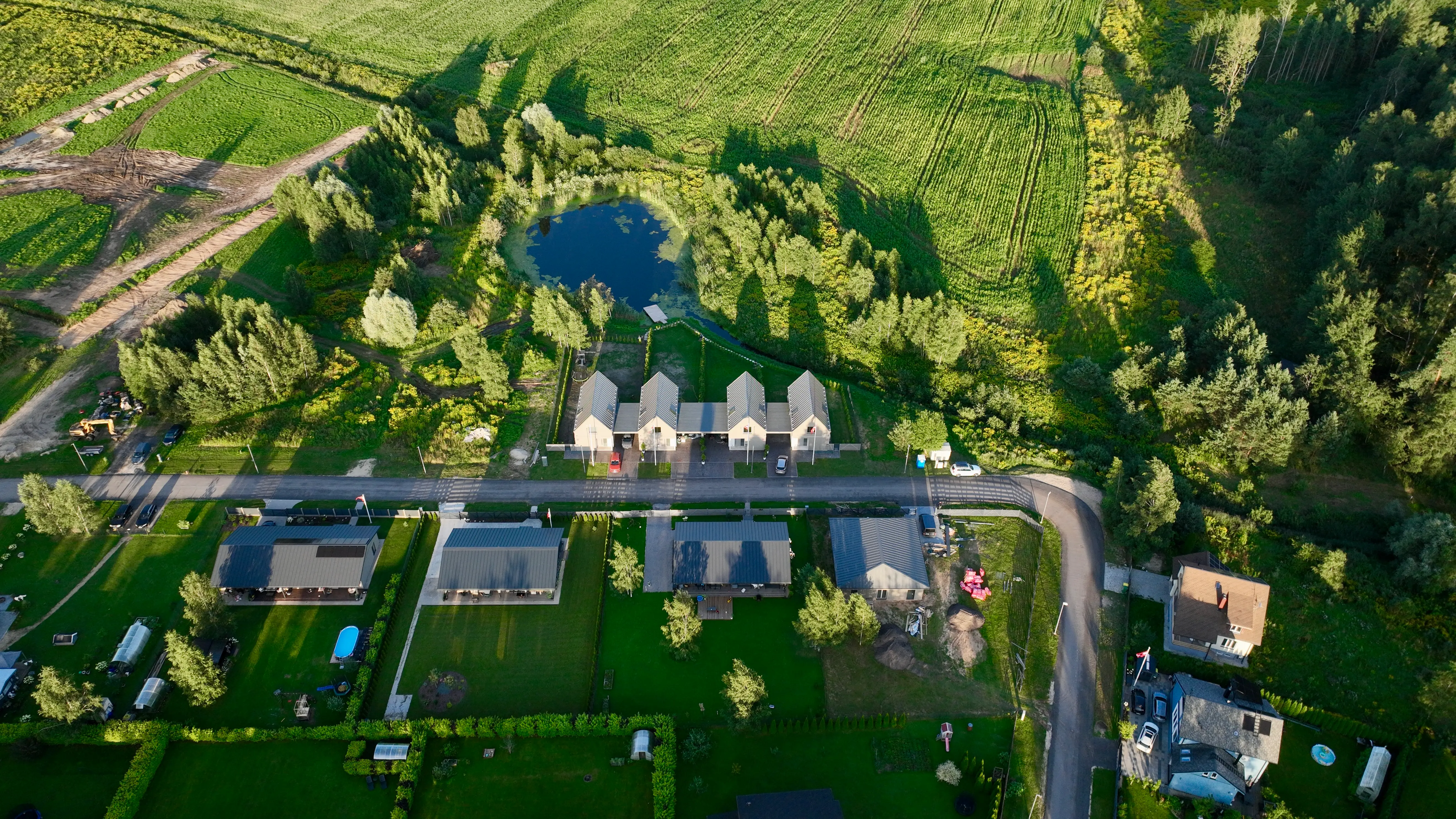 Aerial view of Priežavoti Village — a modern, energy-efficient rental housing project by Grande Build near Riga, Latvia. The site promotes tokenized real estate investment with 10% annual yield through blockchain technology.