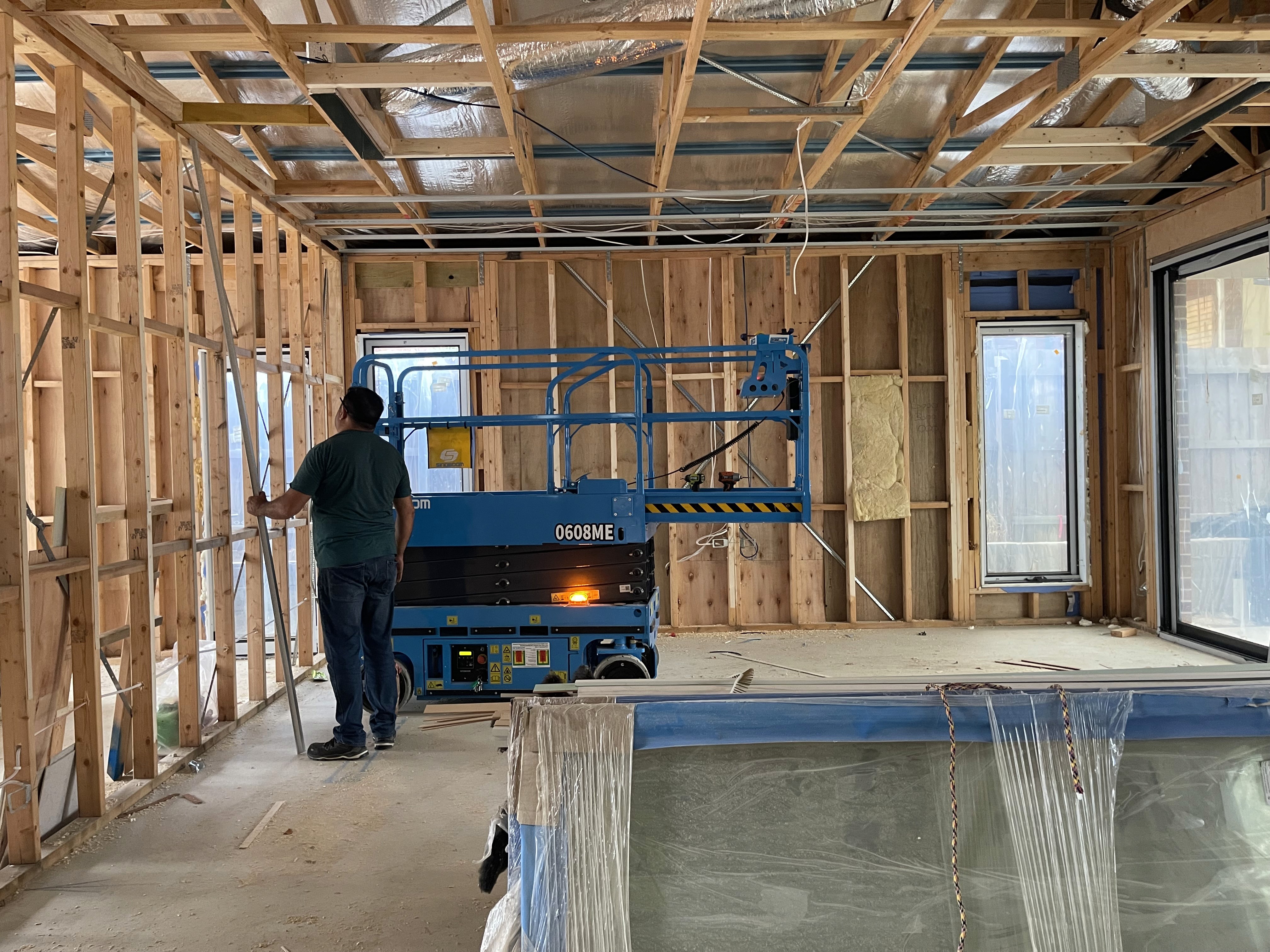 Modern living room with vertical garden, yellow sofas, and stylish coffee tables.