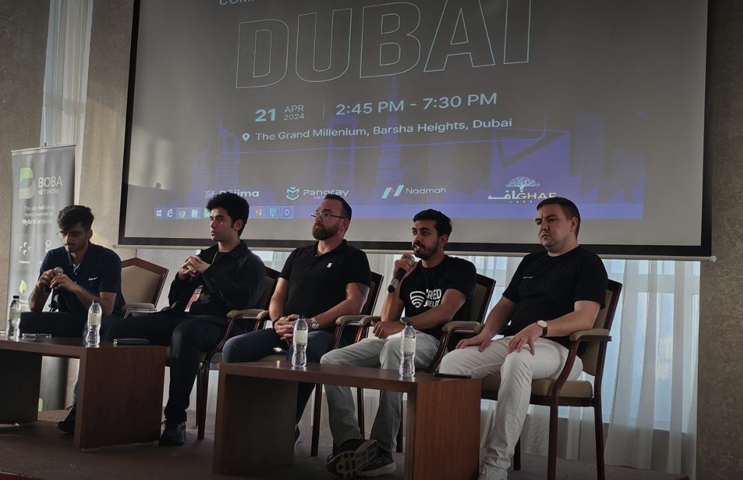 A cozy workspace featuring a wooden desk, a lamp, books, and a plant, illuminated by warm sunlight.