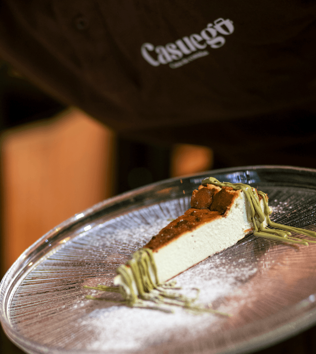 A person lying on a massage table, their face covered with a towel, bathed in warm golden light. The setting exudes relaxation and comfort.