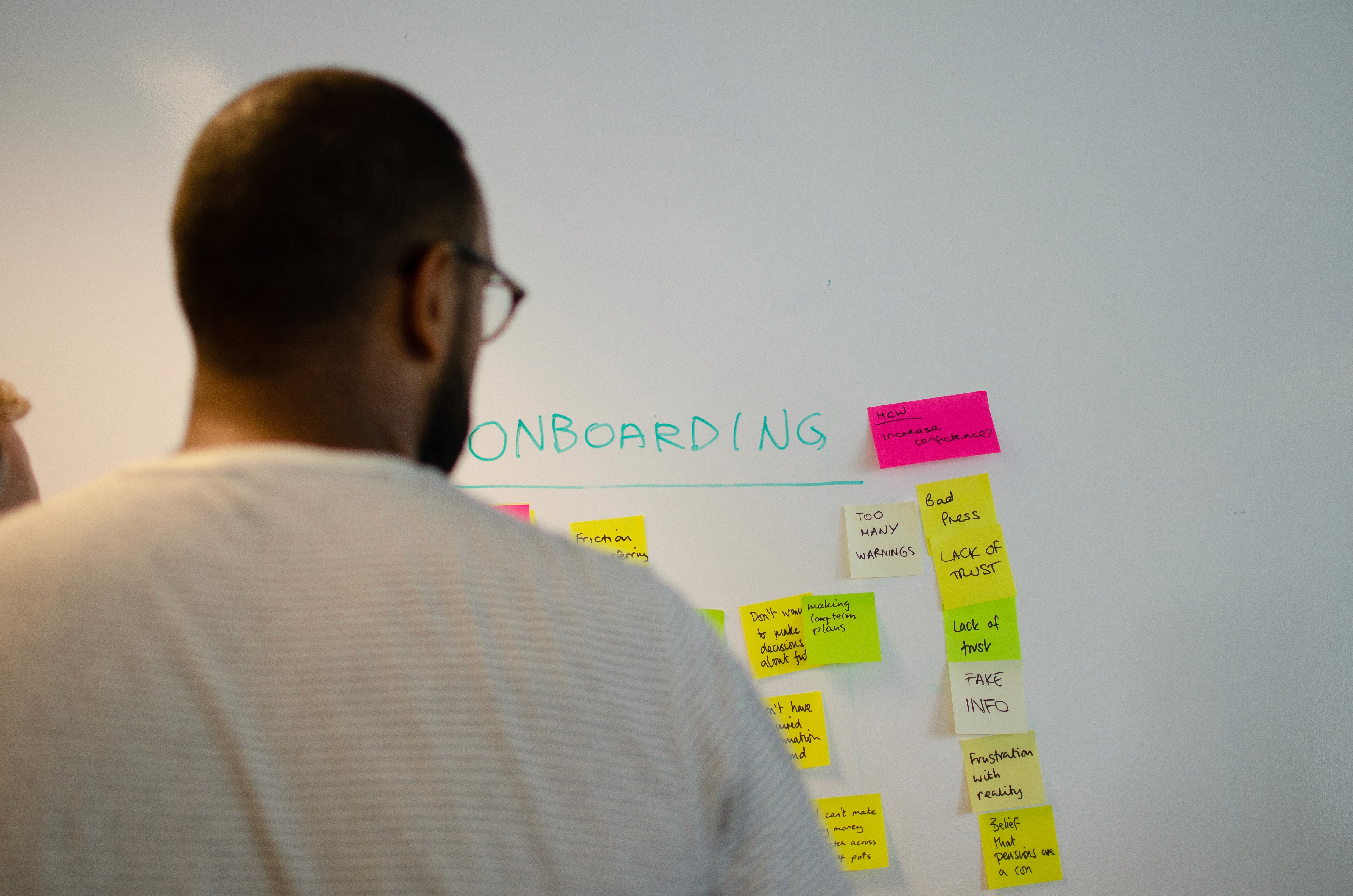 Three individuals gathered around a table, engaged in discussion while examining a laptop.