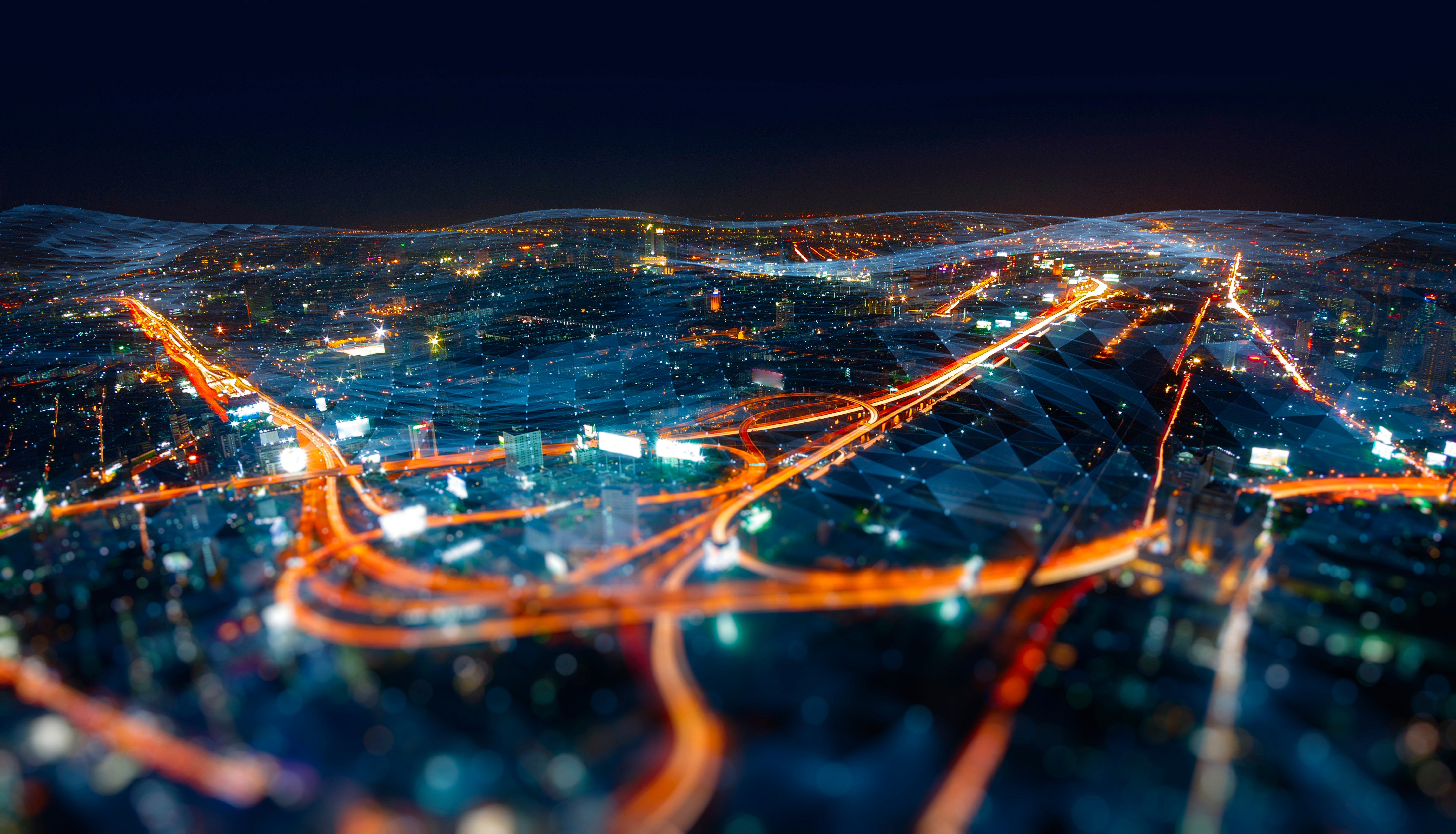 Night-time cityscape with illuminated transport networks and data overlays, symbolising future foresight, risk analysis, and decision-making under uncertainty.