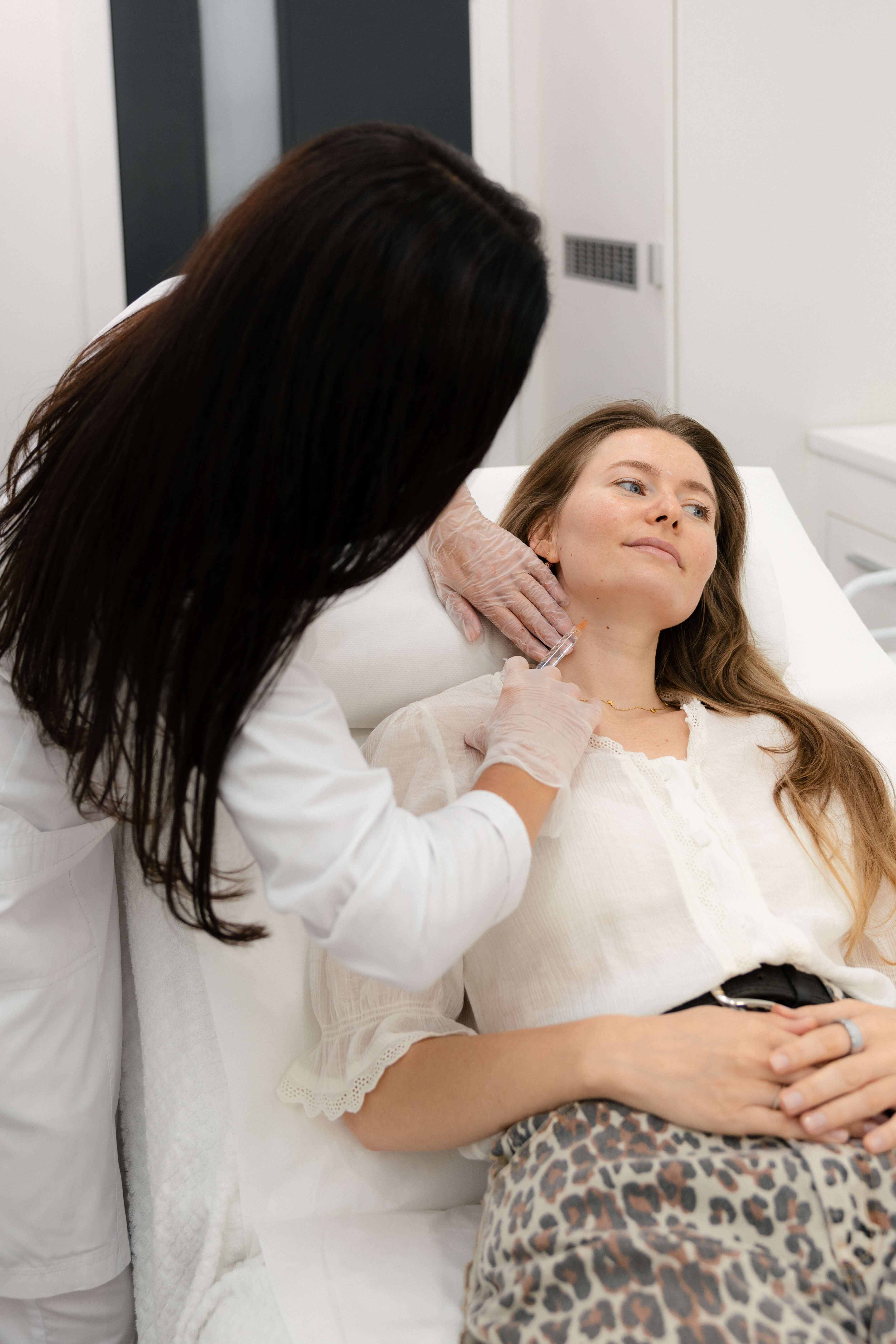 Aesthetic practitioner administering an injectable treatment to a client’s neck at SIGMA Skin Clinic.