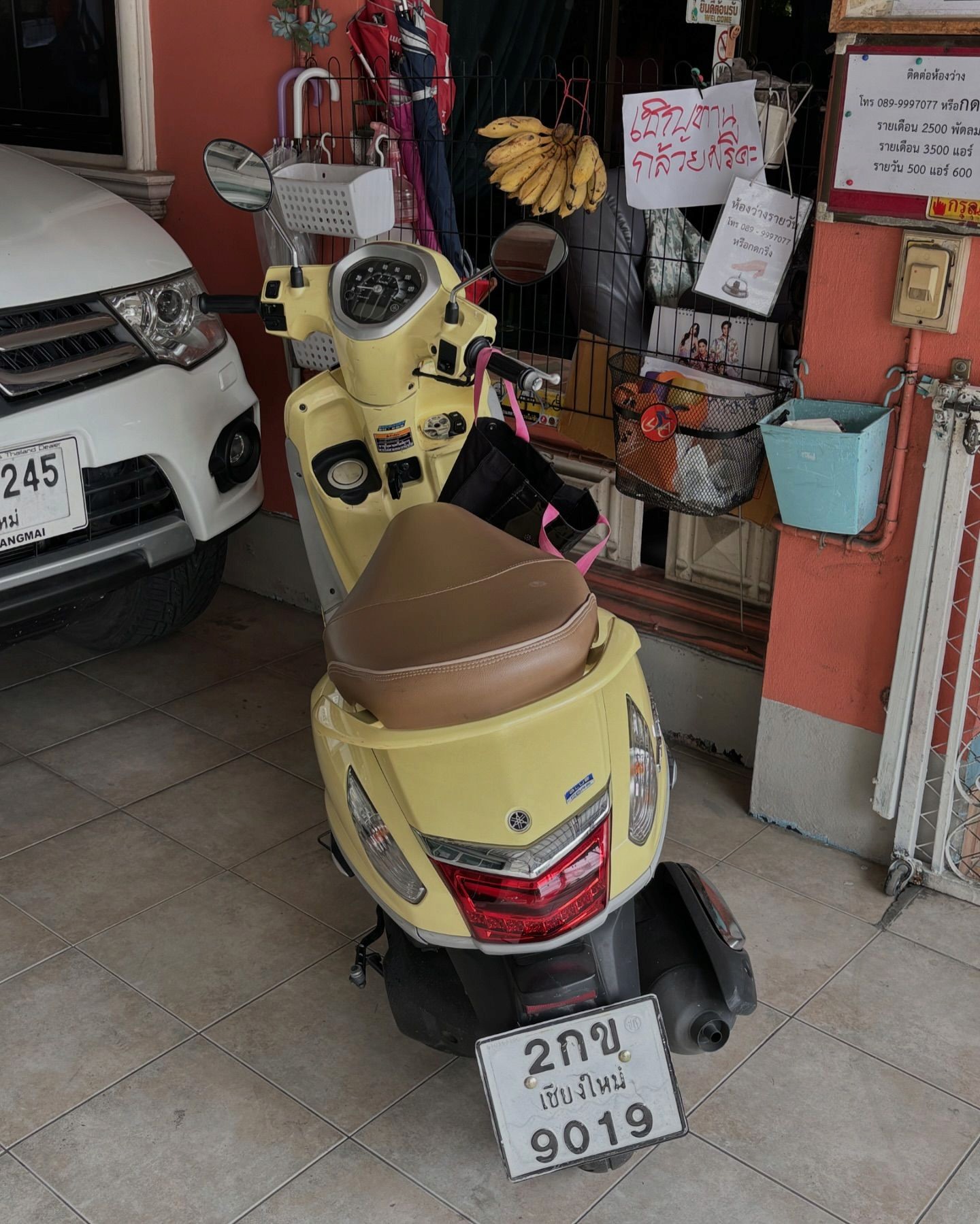 어느 한 가게에 주차된 파스텔 톤의 예쁜 스쿠터 