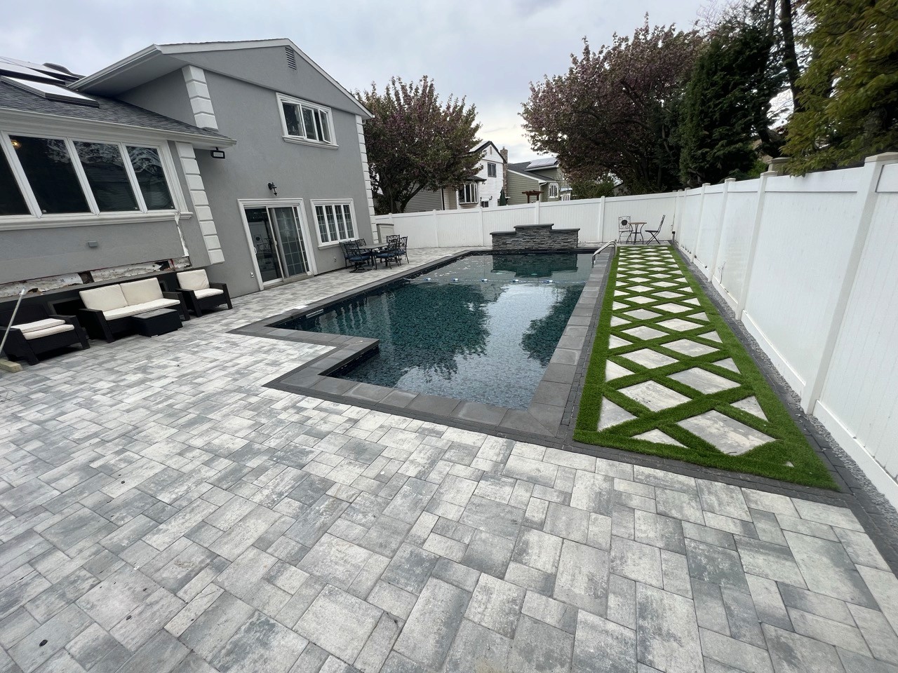 In-ground pool with stepping-stone paver walkway by CMC Masonry on Long Island