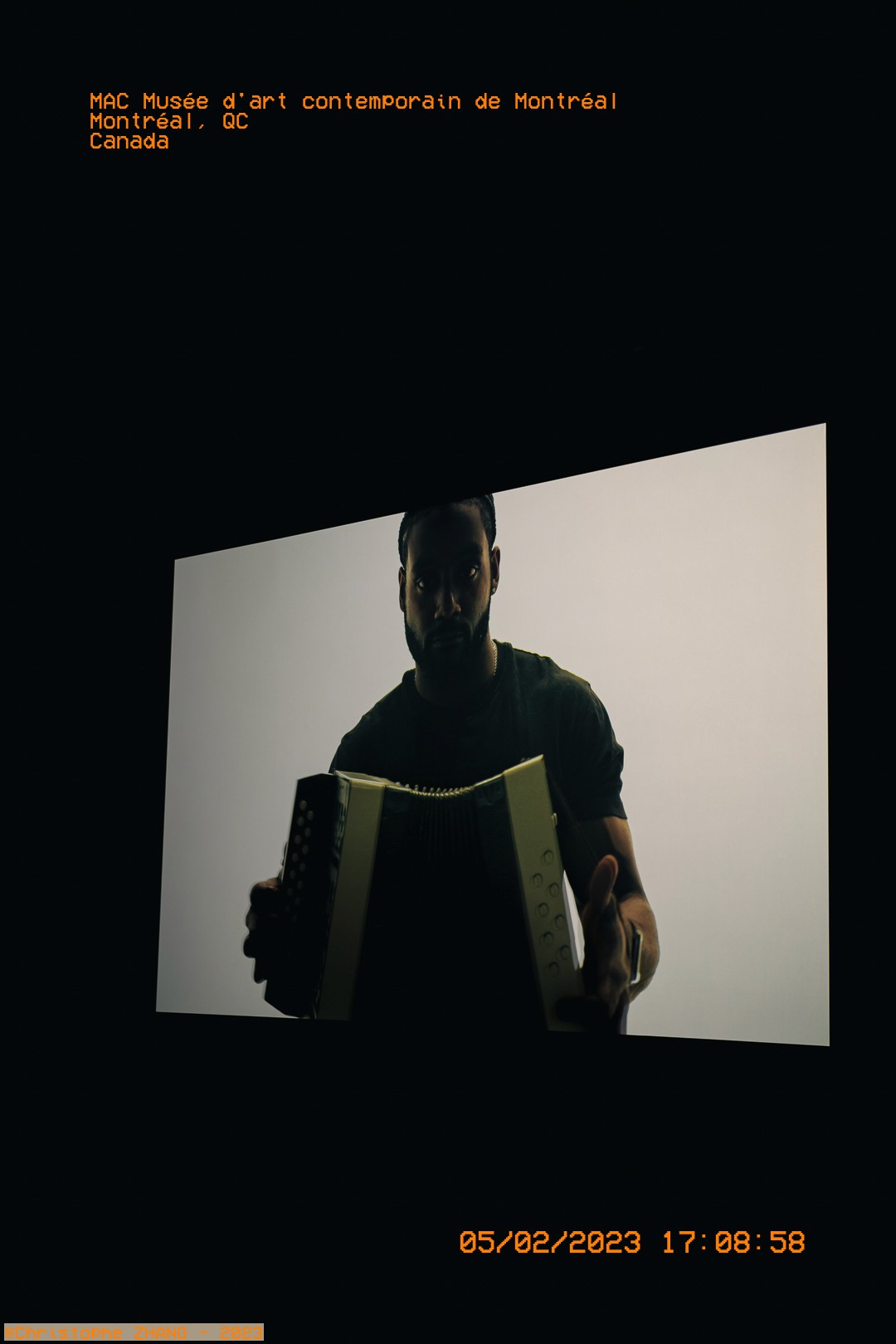Image vidéo d'un musicien avec un accordéon dans une exposition au MAC Montréal.