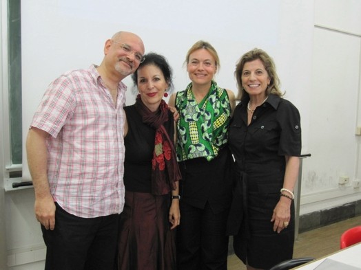 three women and one man in front of projection board