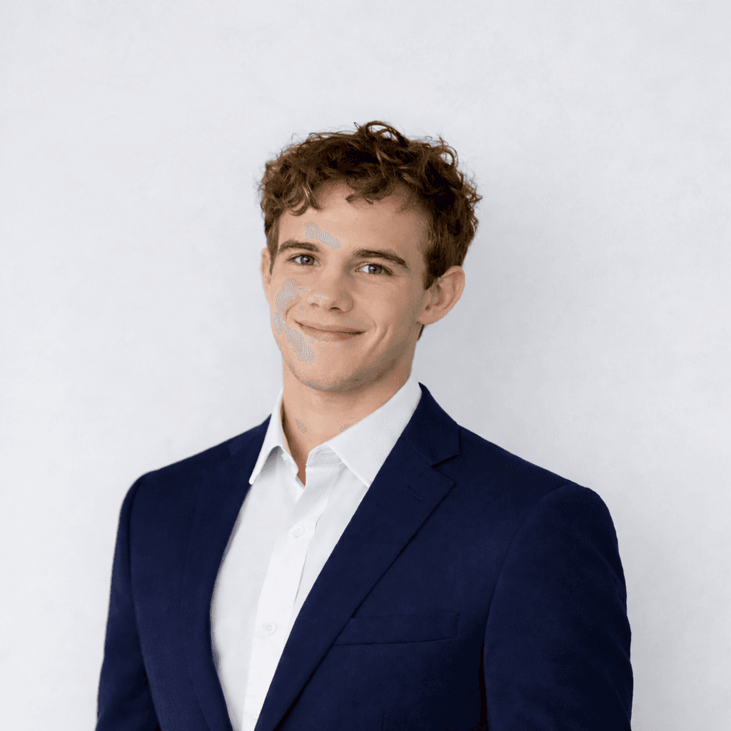 Professional headshot of a brunette woman in a white shirt, arms crossed, on a clean minimal background.