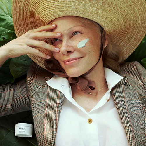 A lifestyle photograph featuring Pamela Anderson with Sonsie adapt cream in a VIVOMER tub. This high-profile application highlights the premium appeal and commercial readiness of Shellworks' compostable packaging.