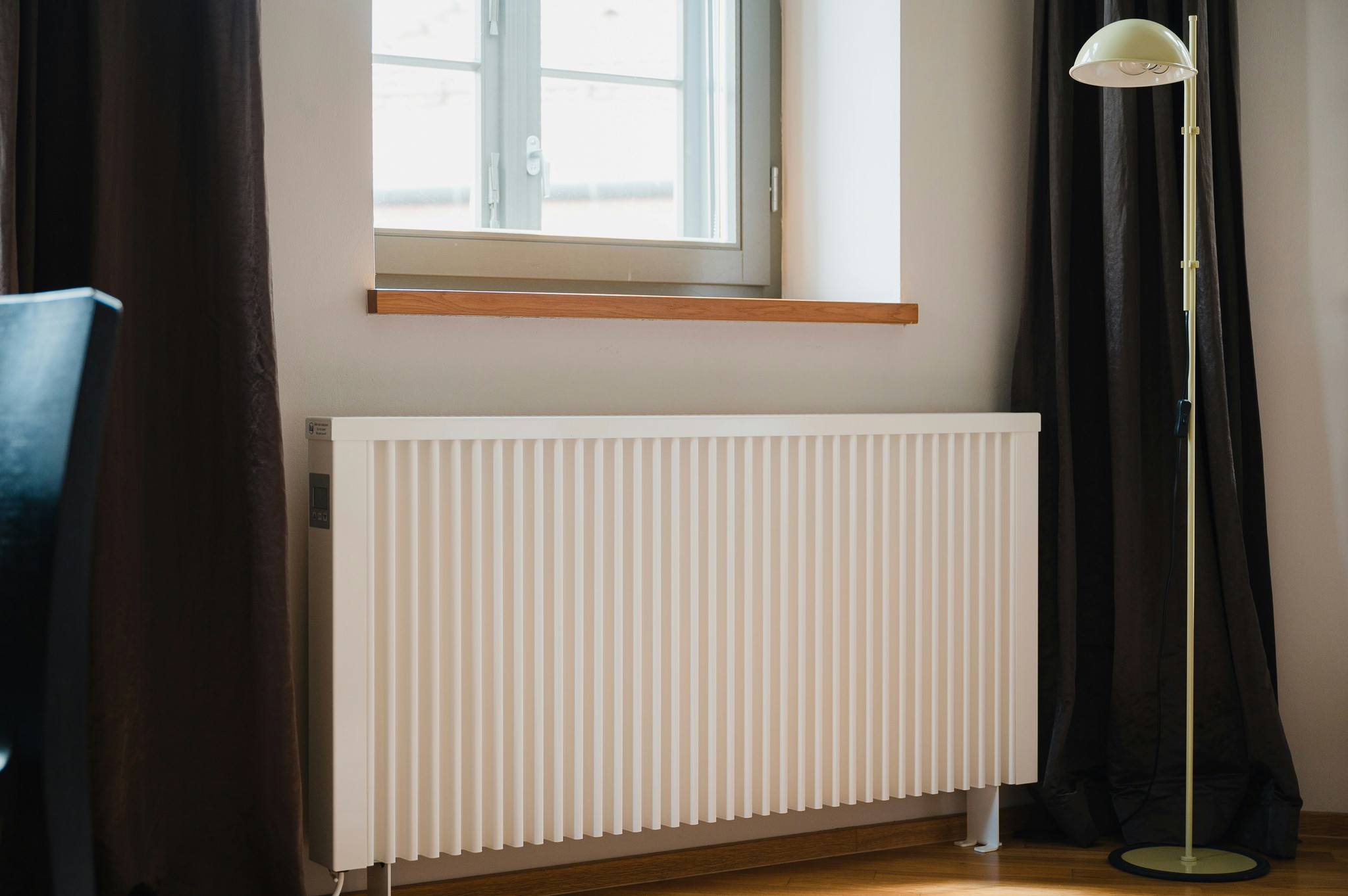 A wall-mounted electric storage heater in a residential setting.