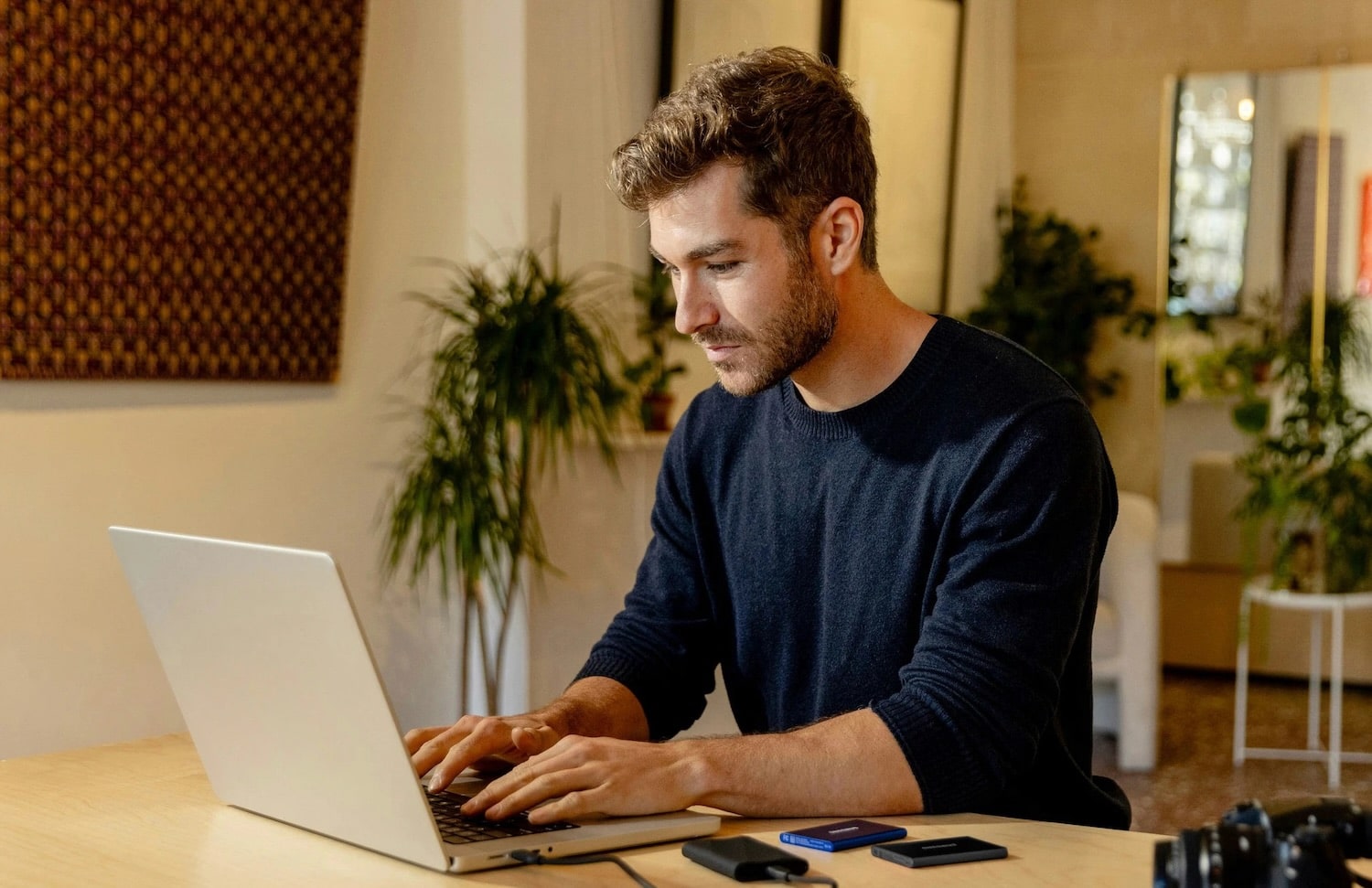 Man holding sd card with camera and mountain landscape.