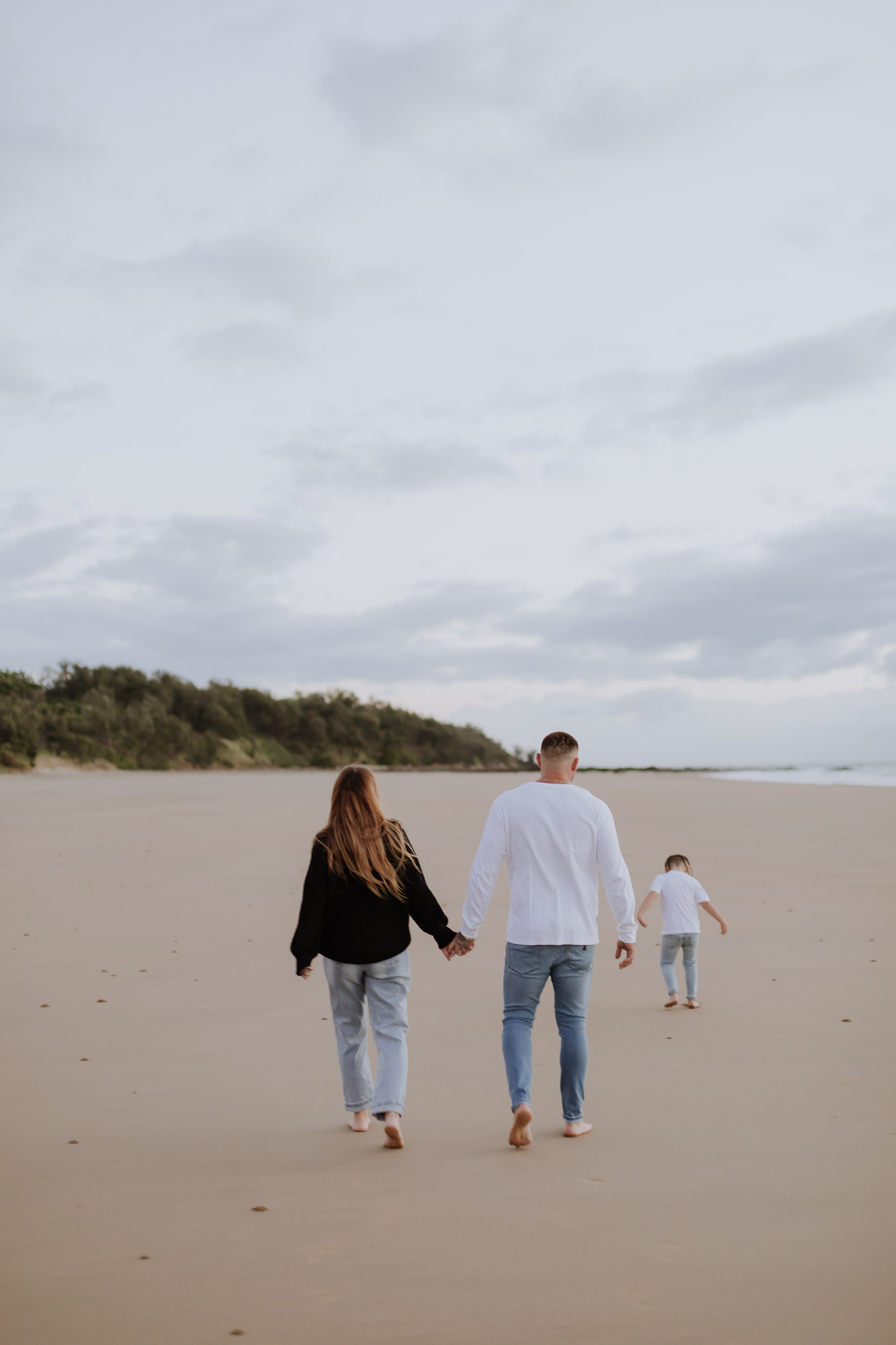 Family photoshoot at Mackay beach during sunrise with children playing near the shoreline