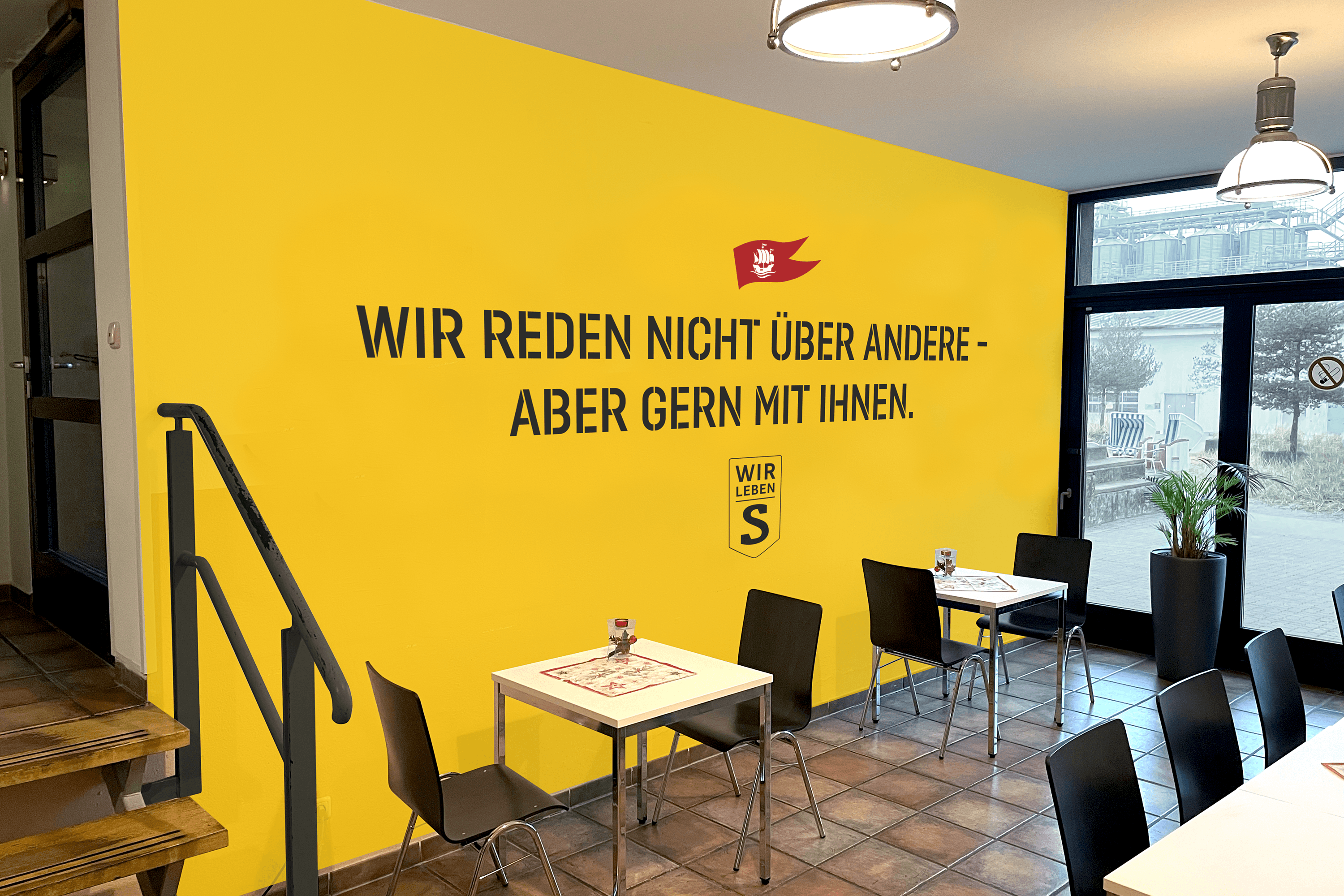 Yellow wall with German text and a logo.