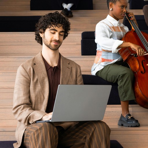 Man with laptop and woman playing cello