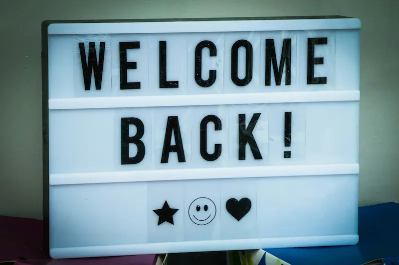 Lightbox with the message 'WELCOME BACK!' flanked by a star, a smiley face, and a heart icon, conveying a warm and friendly greeting.