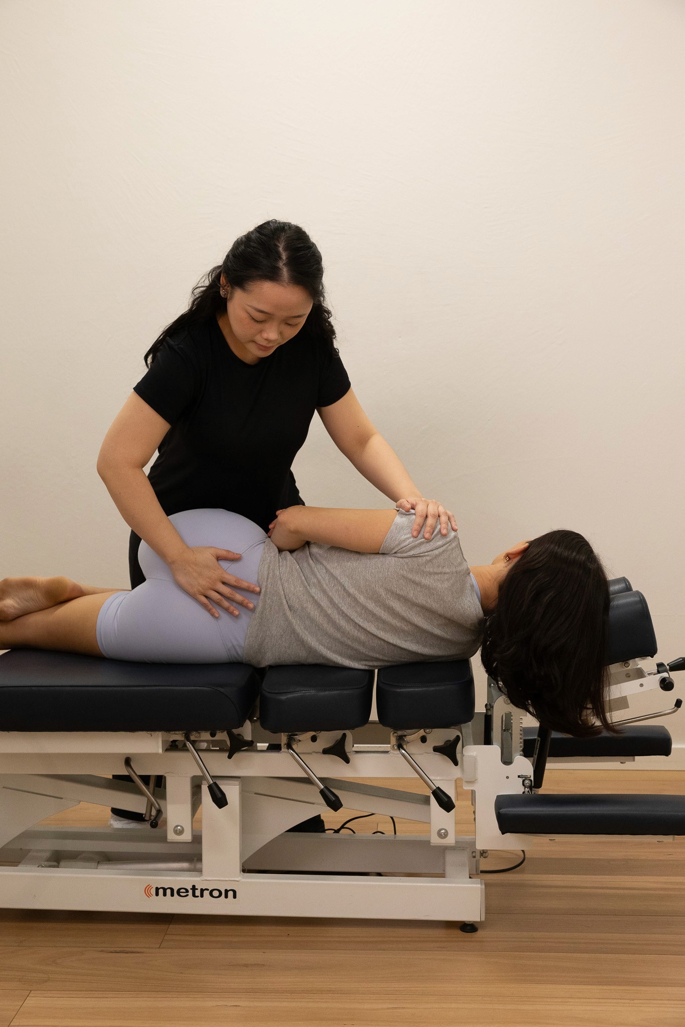 Chiropractor adjusting patient's upper back and neck.