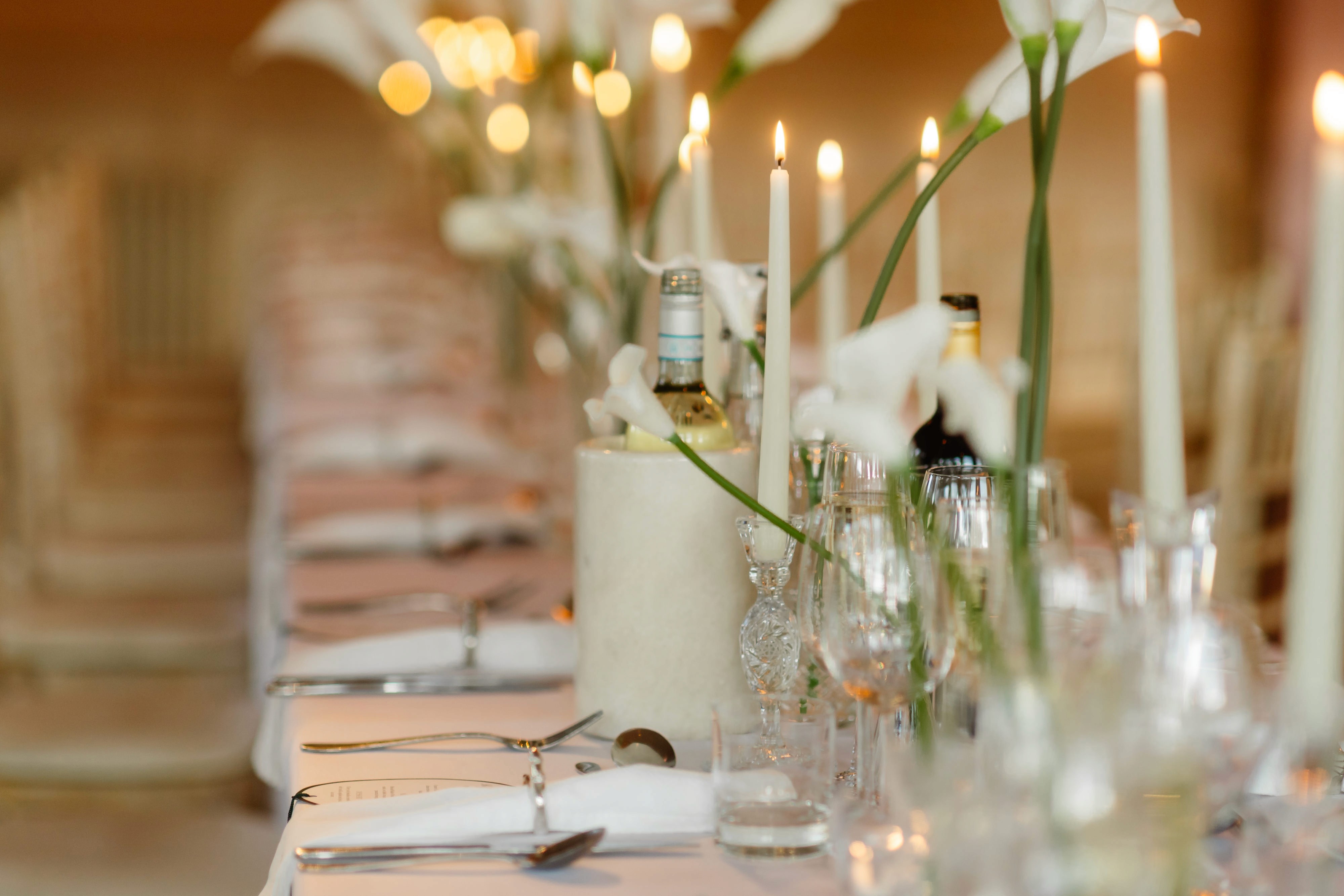 Flowers, candlelight and glassware on Olivia and Jake’s wedding reception table