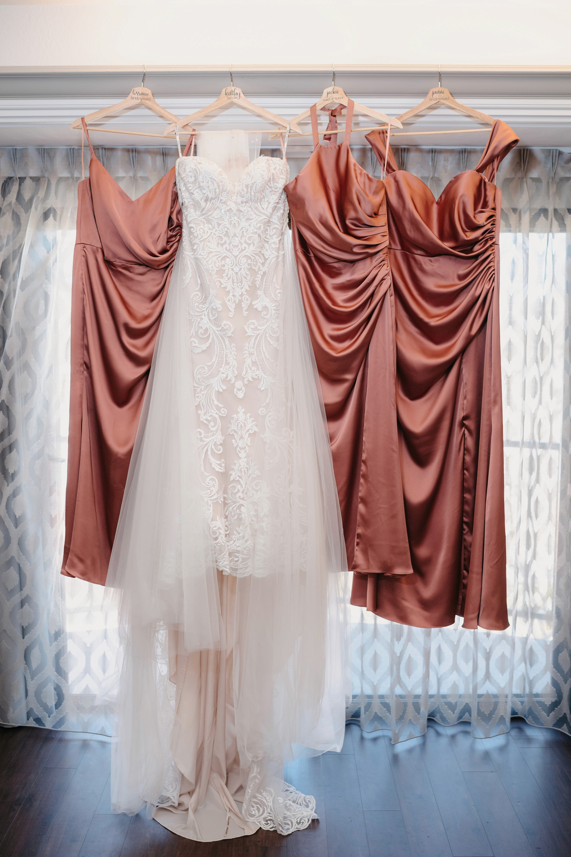 Bride’s wedding dress and bridesmaid dresses hanging in the getting-ready suite