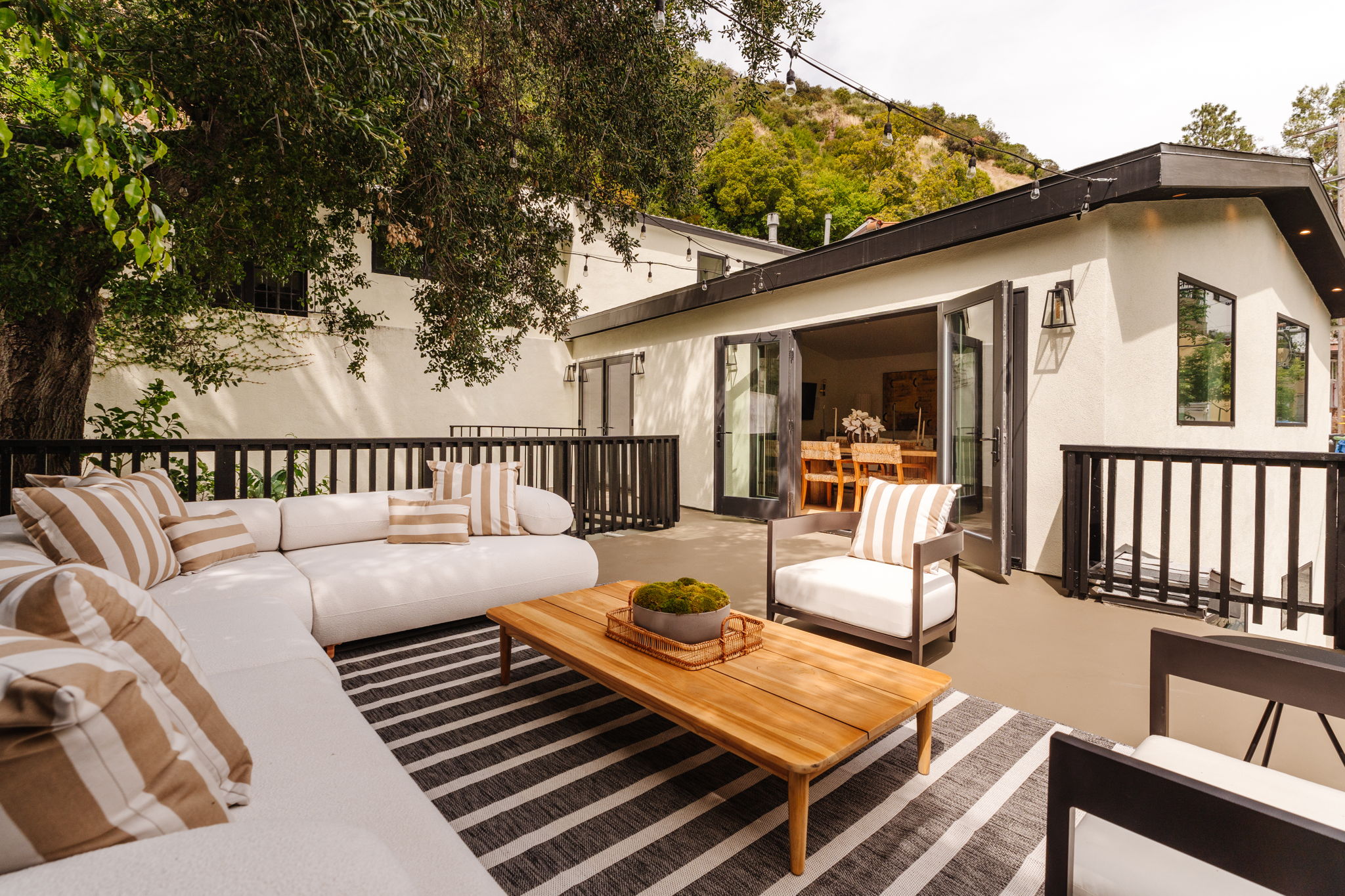 Modern living room with black leather sofas and tree-patterned rug