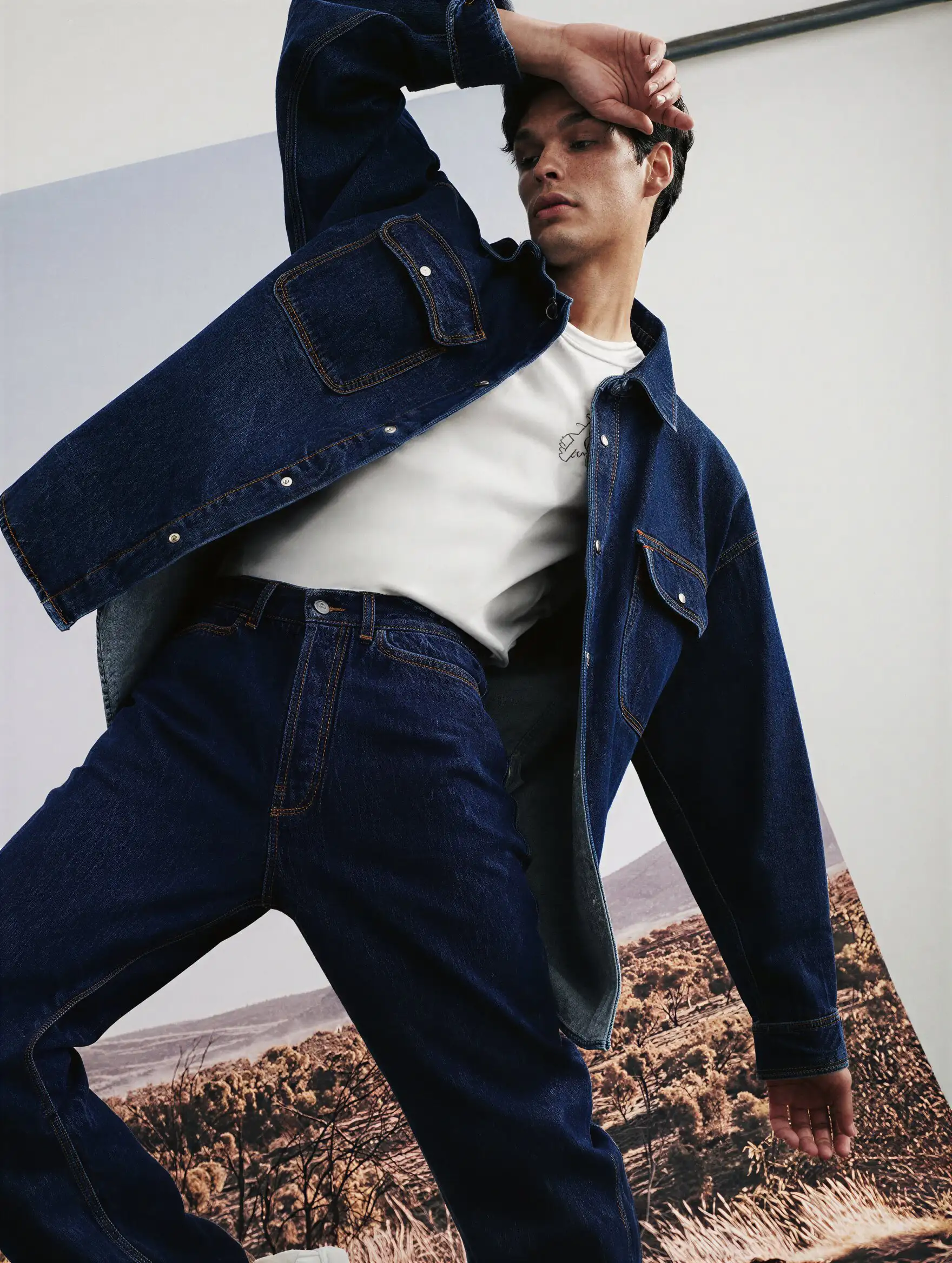 Torii gate silhouetted against a sunset over a city.