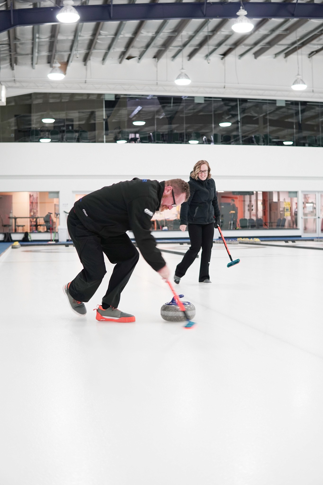 A man and woman enjoying a game of curling 