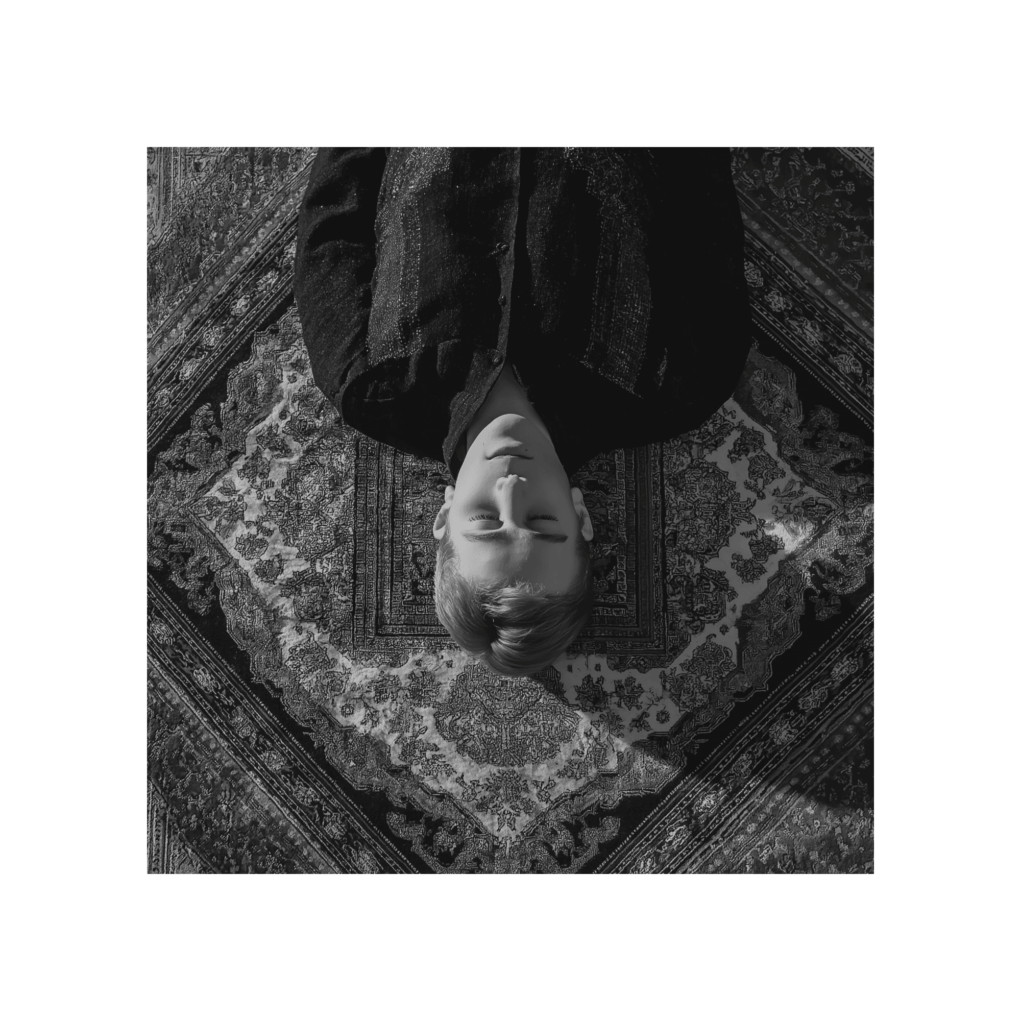 Index collection image, a top view of a young man with traditional clothes lying over a vintage carpet with high contrast light