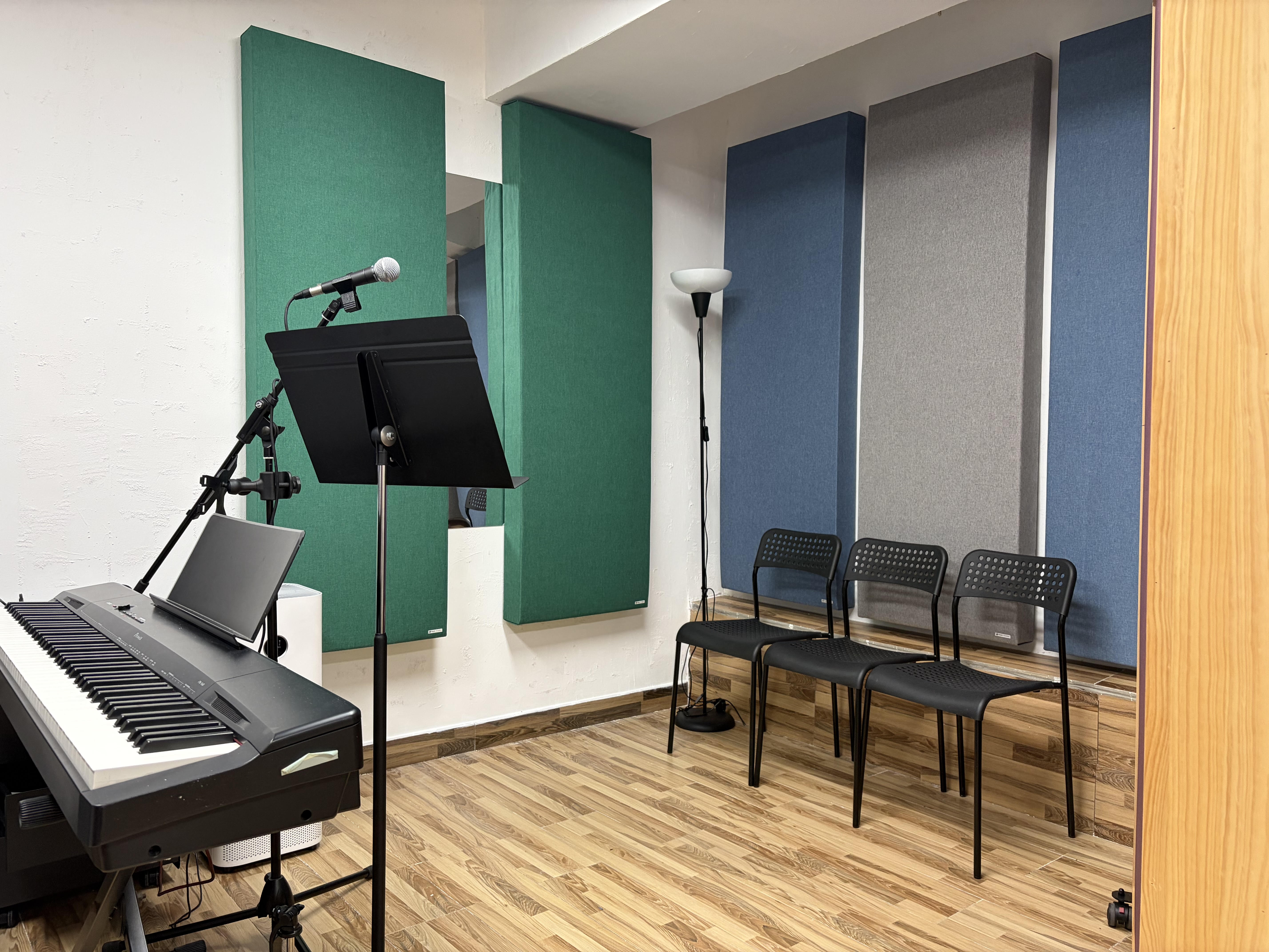 Vincent Tsoi’s vocal studio in Kowloon Bay with microphones, keyboards, music stands, and acoustic panels