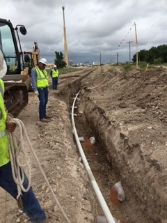 a woman sitting at a table with two laptops