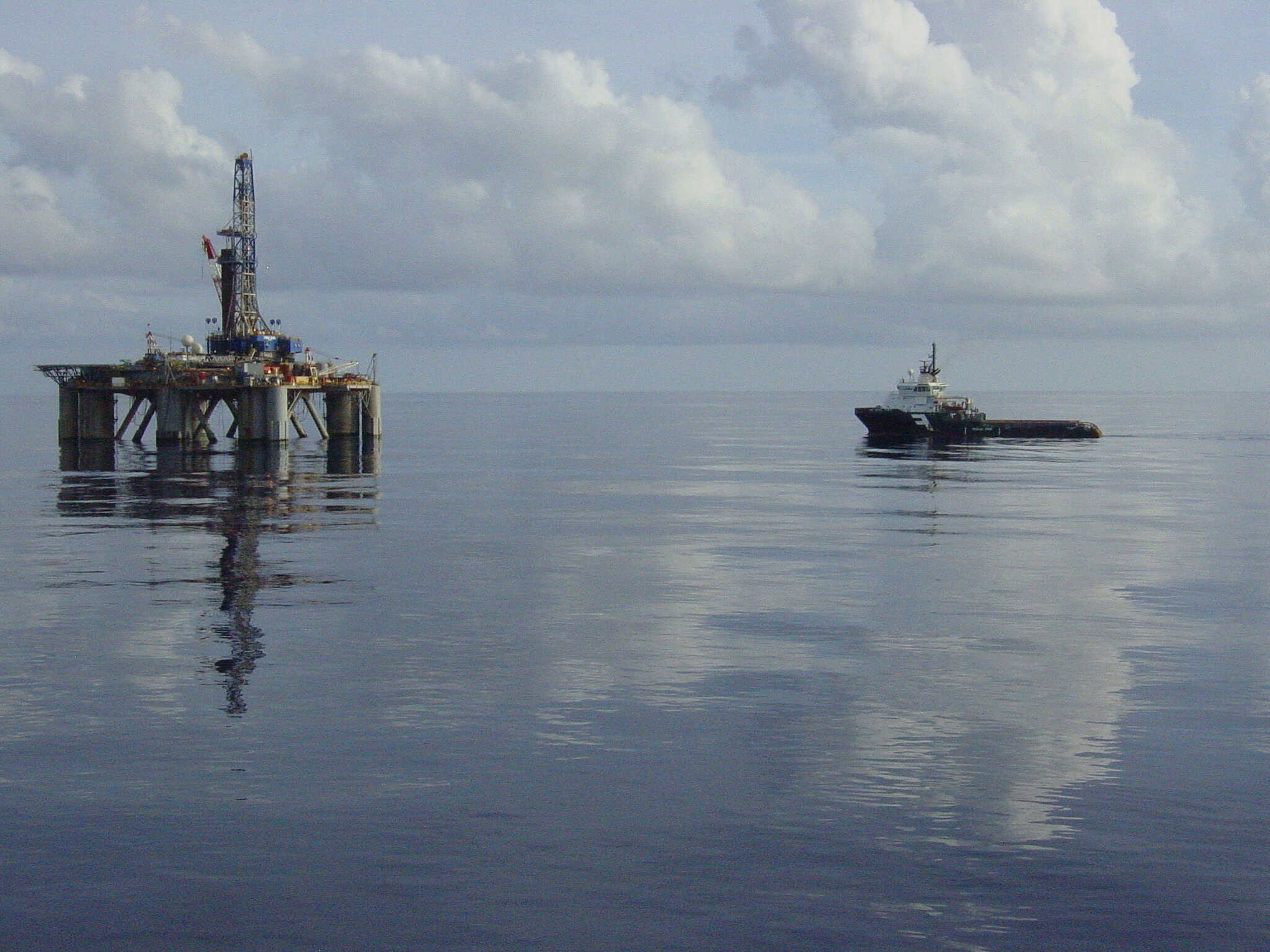 Offshore drilling rig in remote location with supply vessel nearby