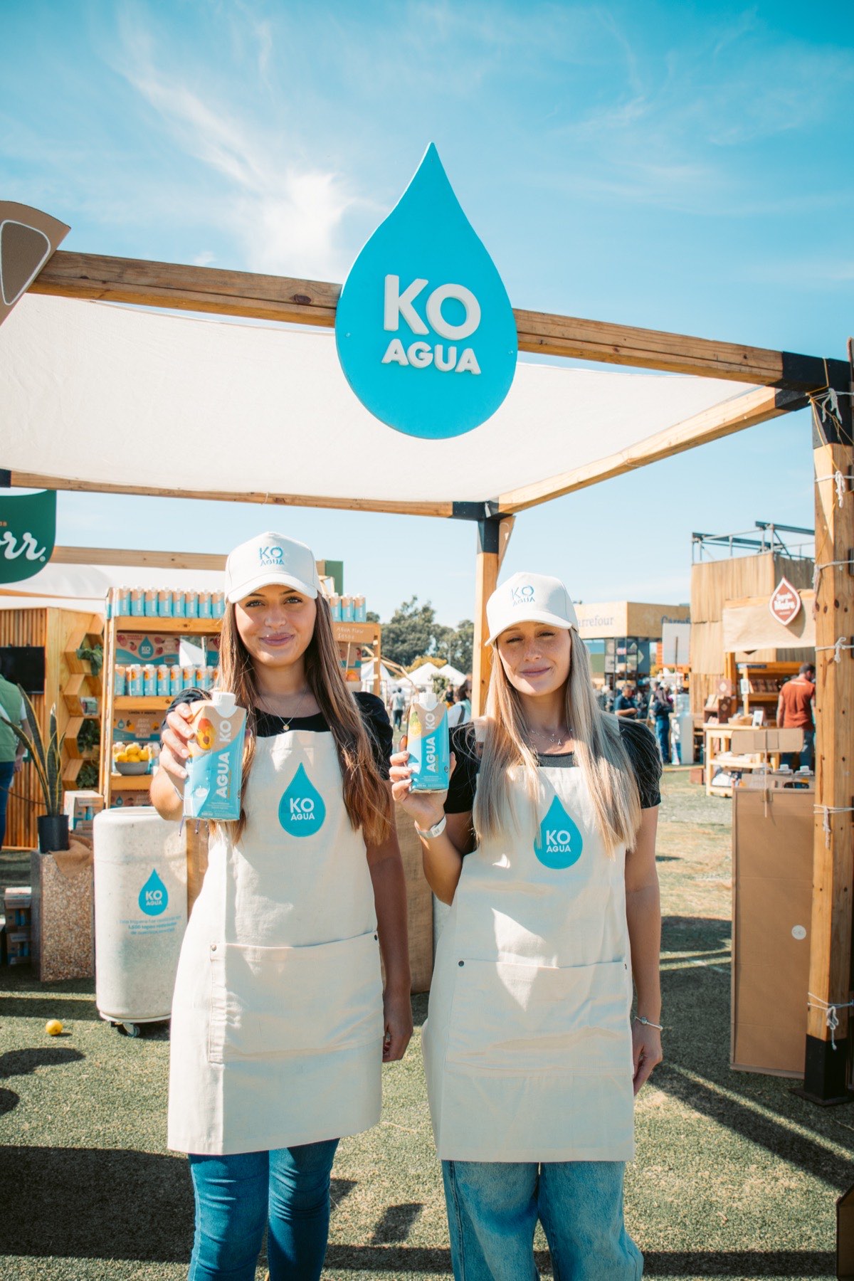 Dos expositoras con delantales de «KO Agua» en su stand