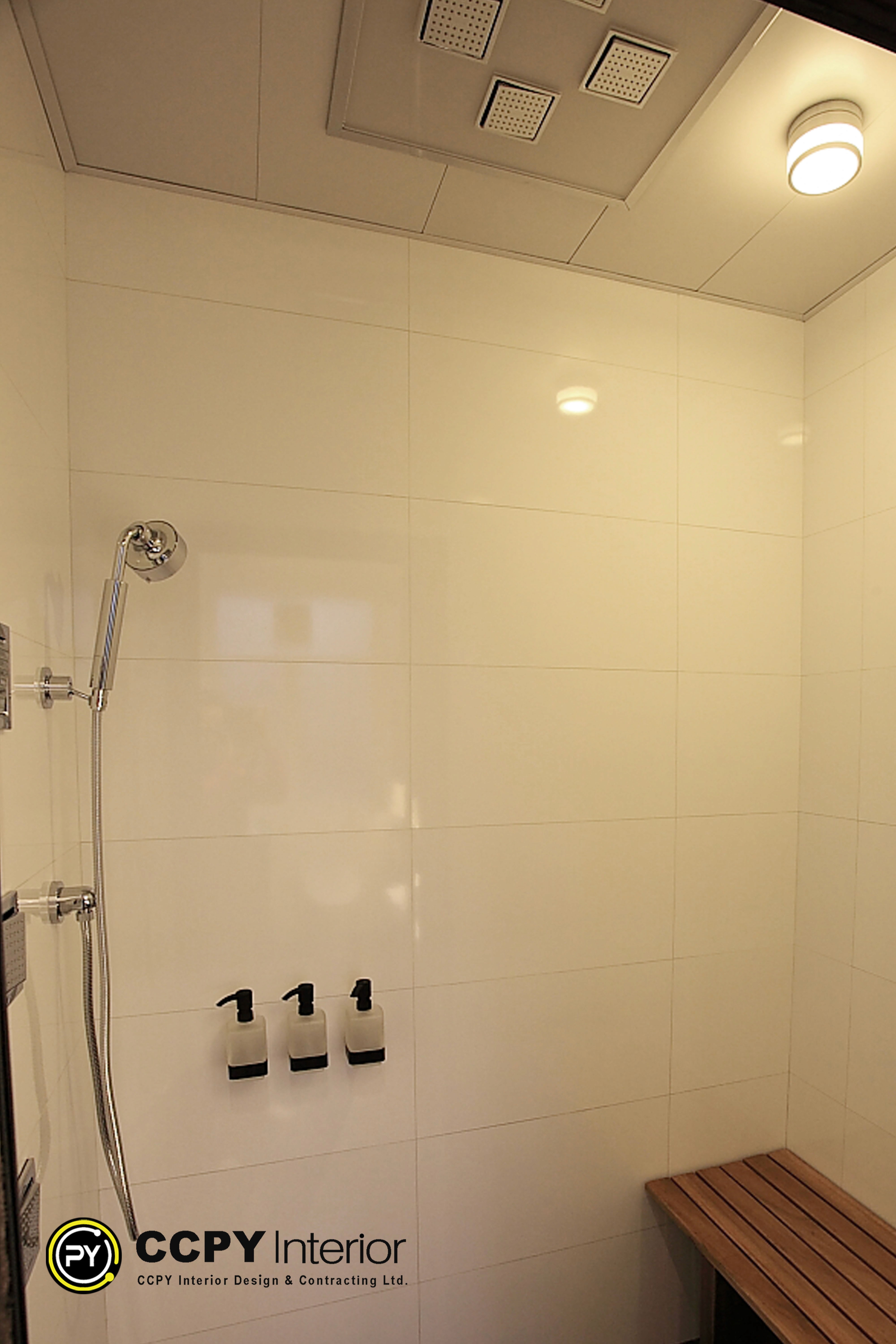 Shower area at Standalone House, Perkins Road featuring a natural teak slatted bench and wall-mounted frosted glass dispensers.