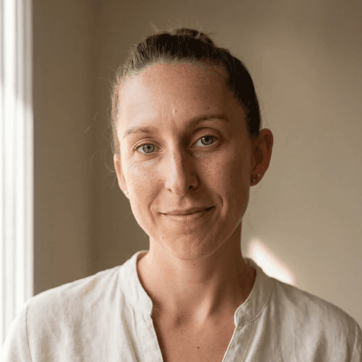 a woman in a white shirt is holding her ear